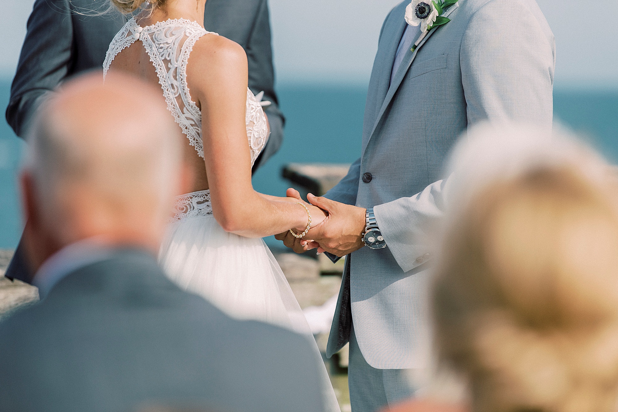 groom holds bride's hands during vows