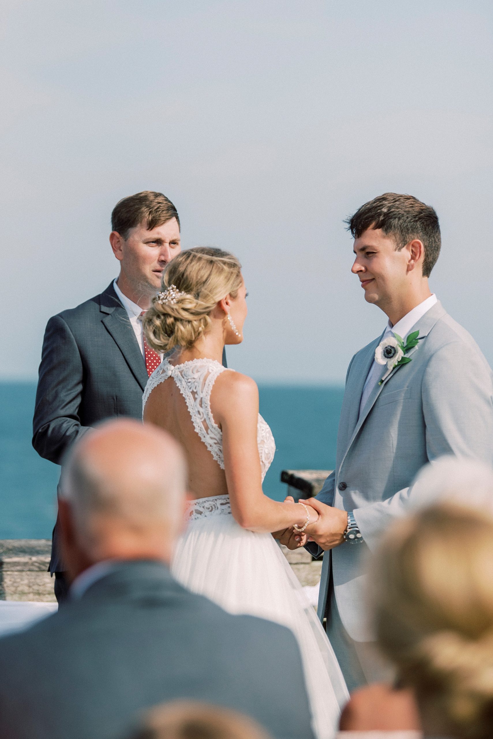 bride and groom exchange vows during waterfront wedding ceremony in Wrightsville Beach
