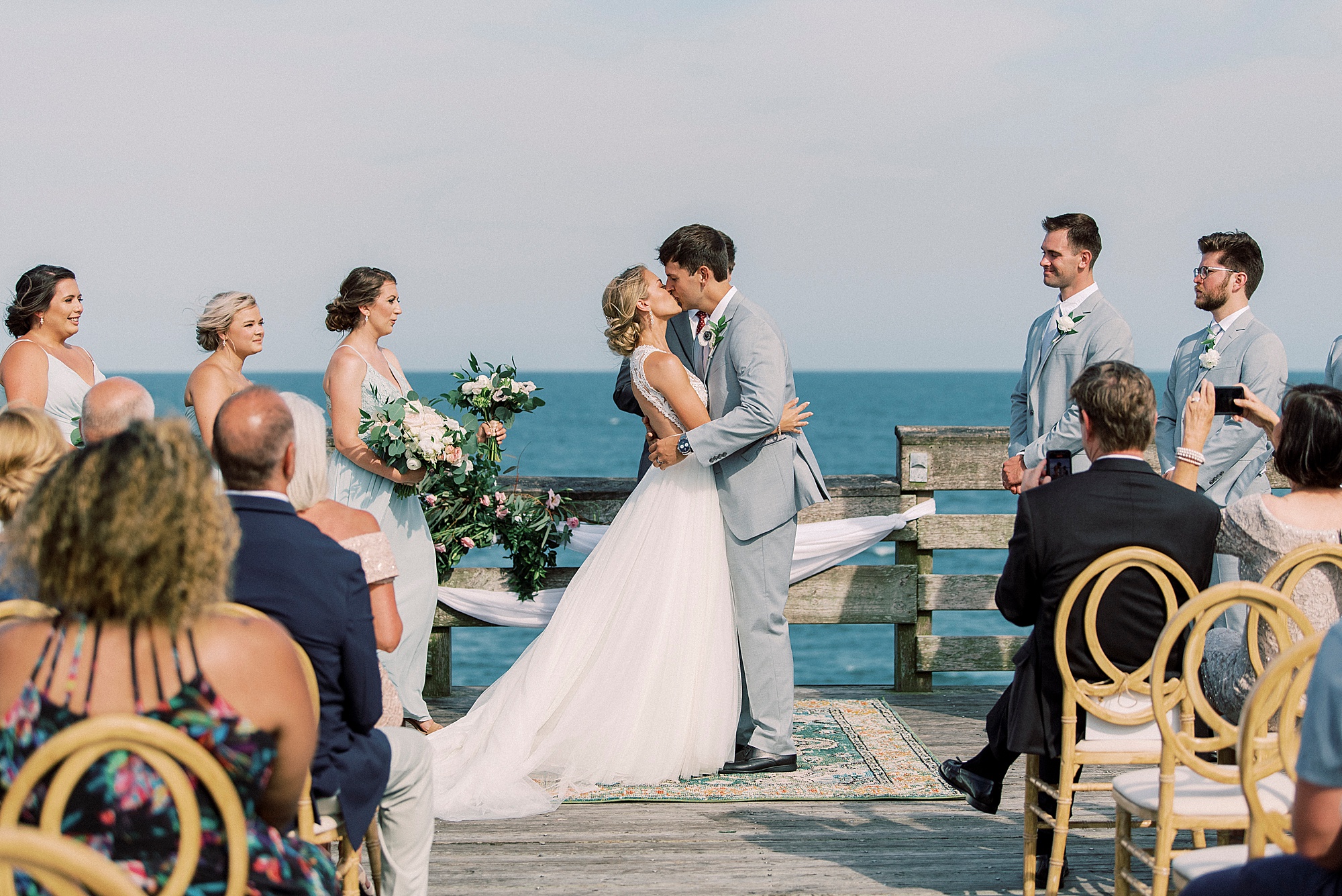 bride and groom kiss during waterfront wedding ceremony in Wrightsville Beach
