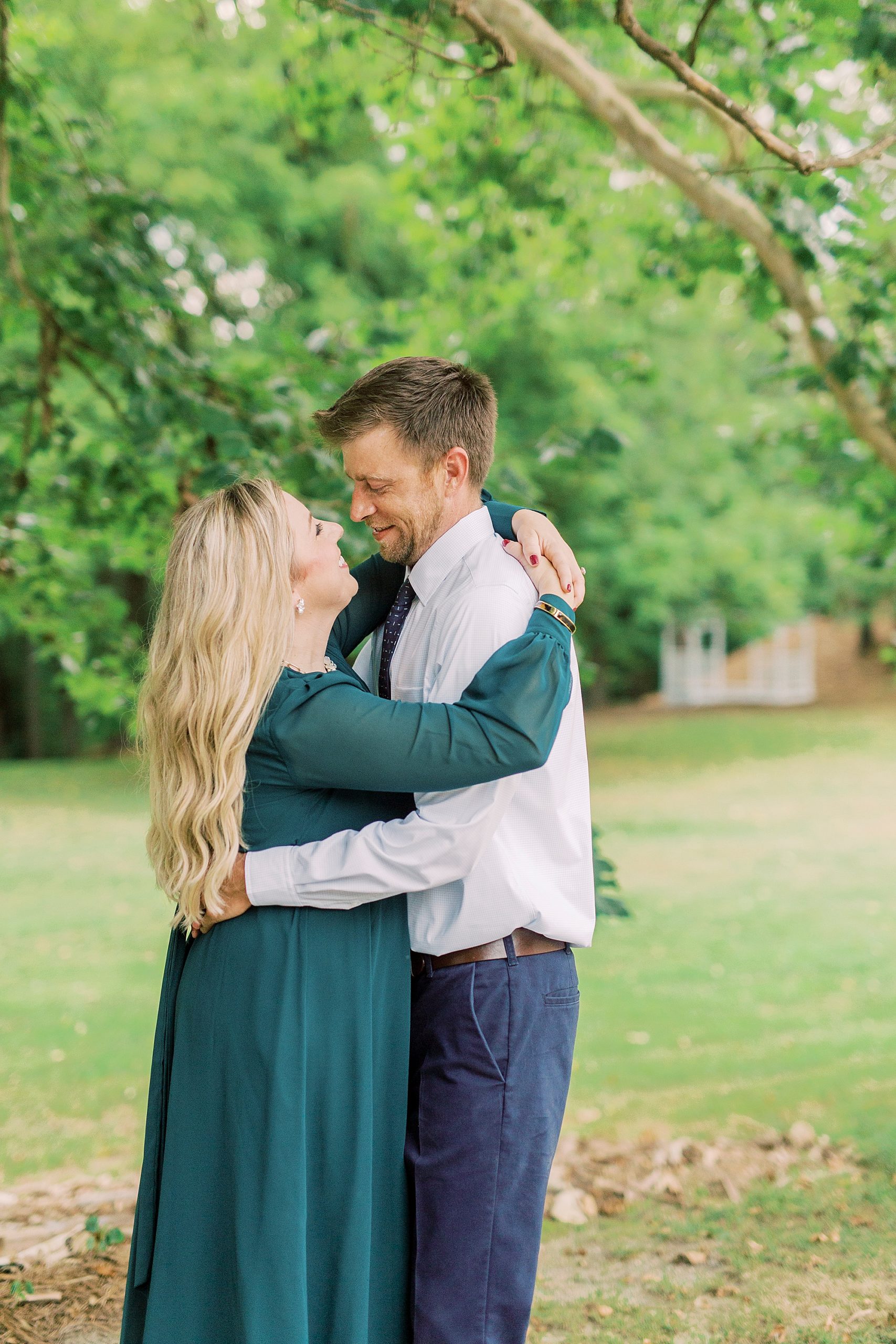 engaged couple hugs under trees in Iron Station NC