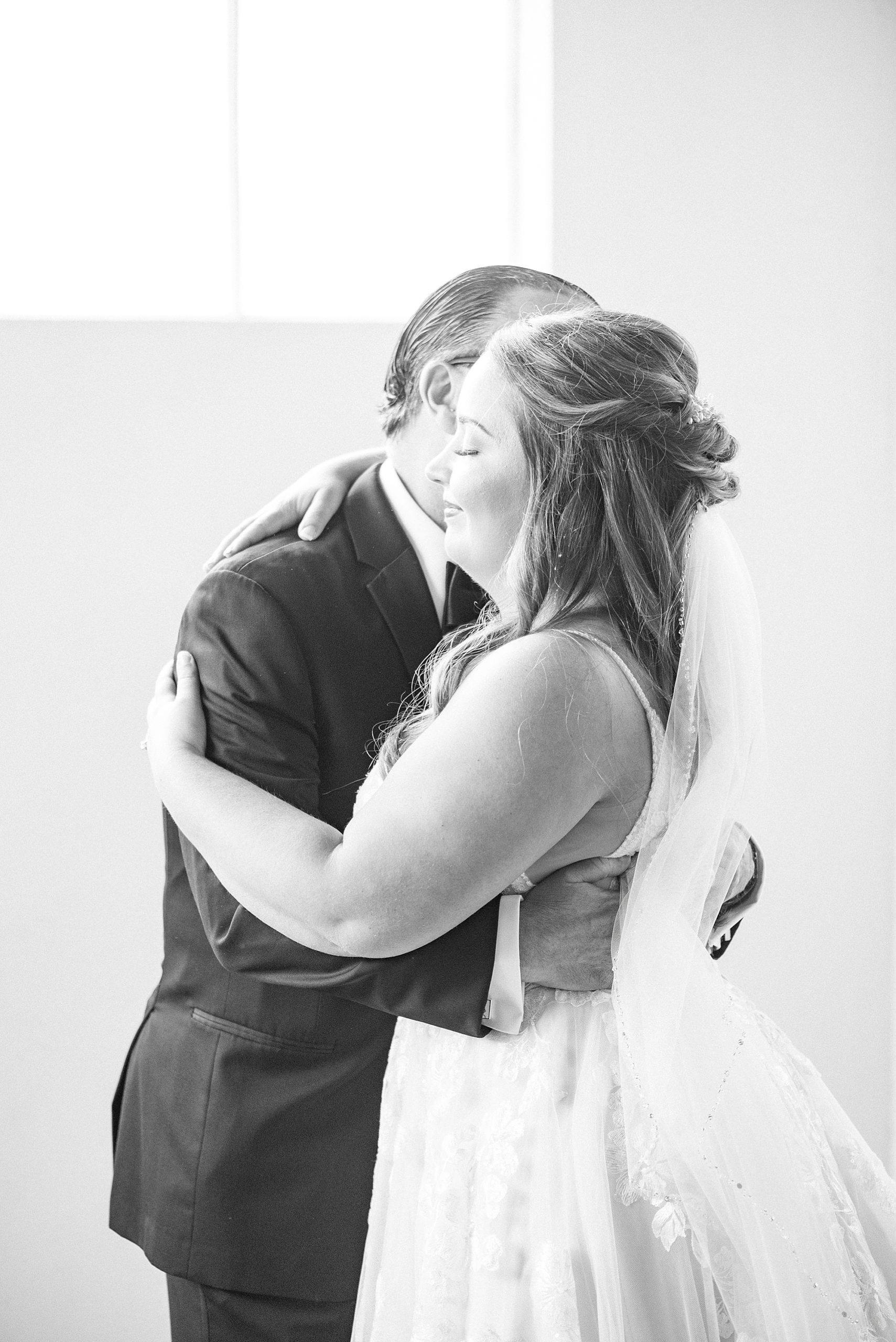 dad and bride hug during first look at Cadillac Service Garage