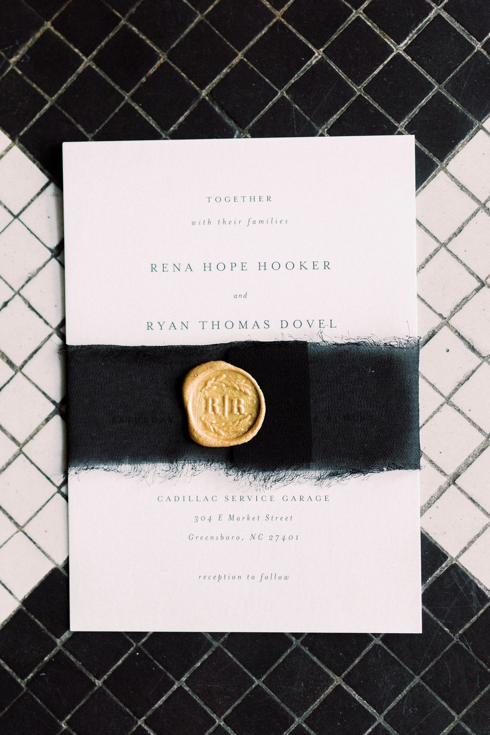 black and white wedding invitation with gold seal