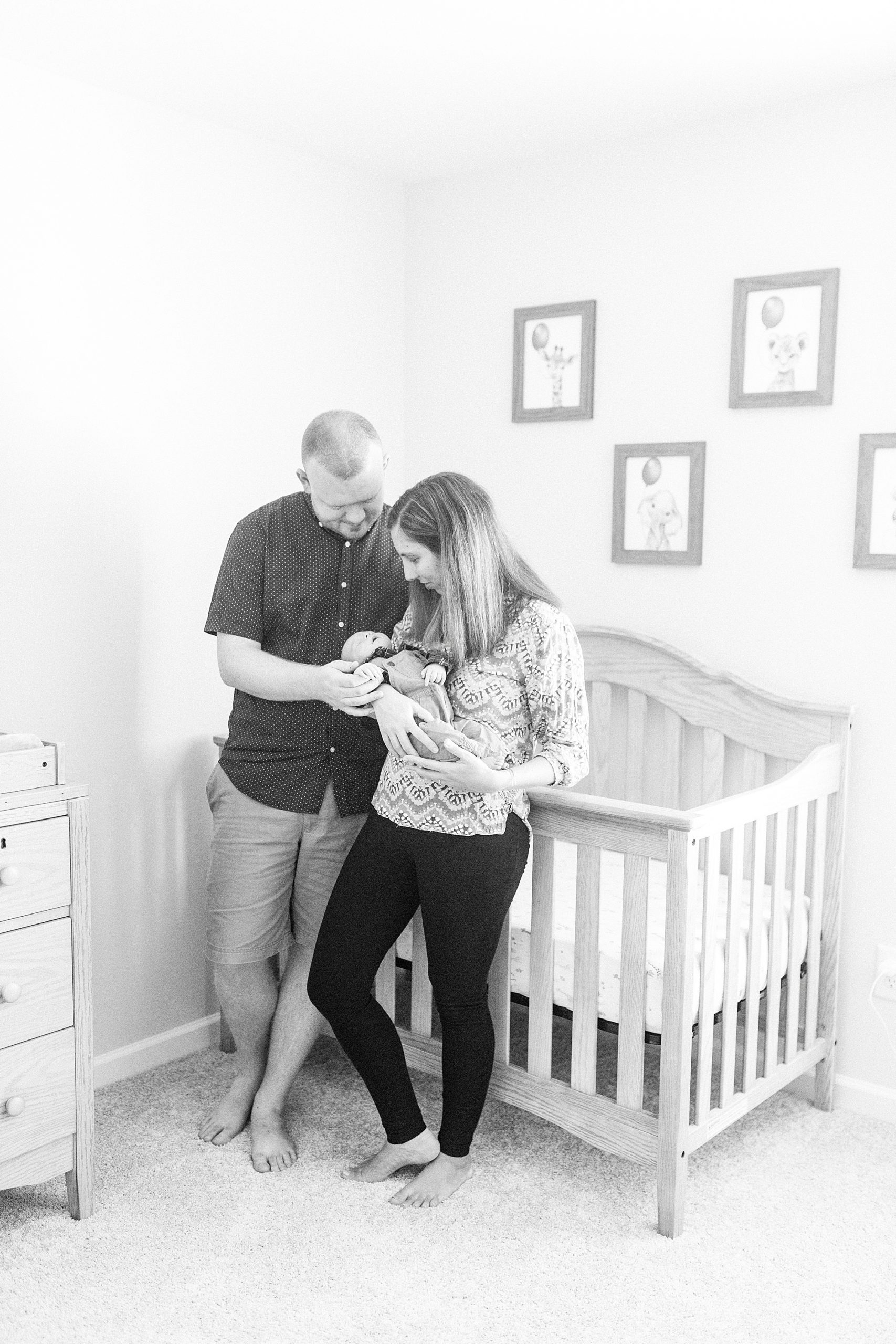 parents hold son by crib during lifestyle newborn session