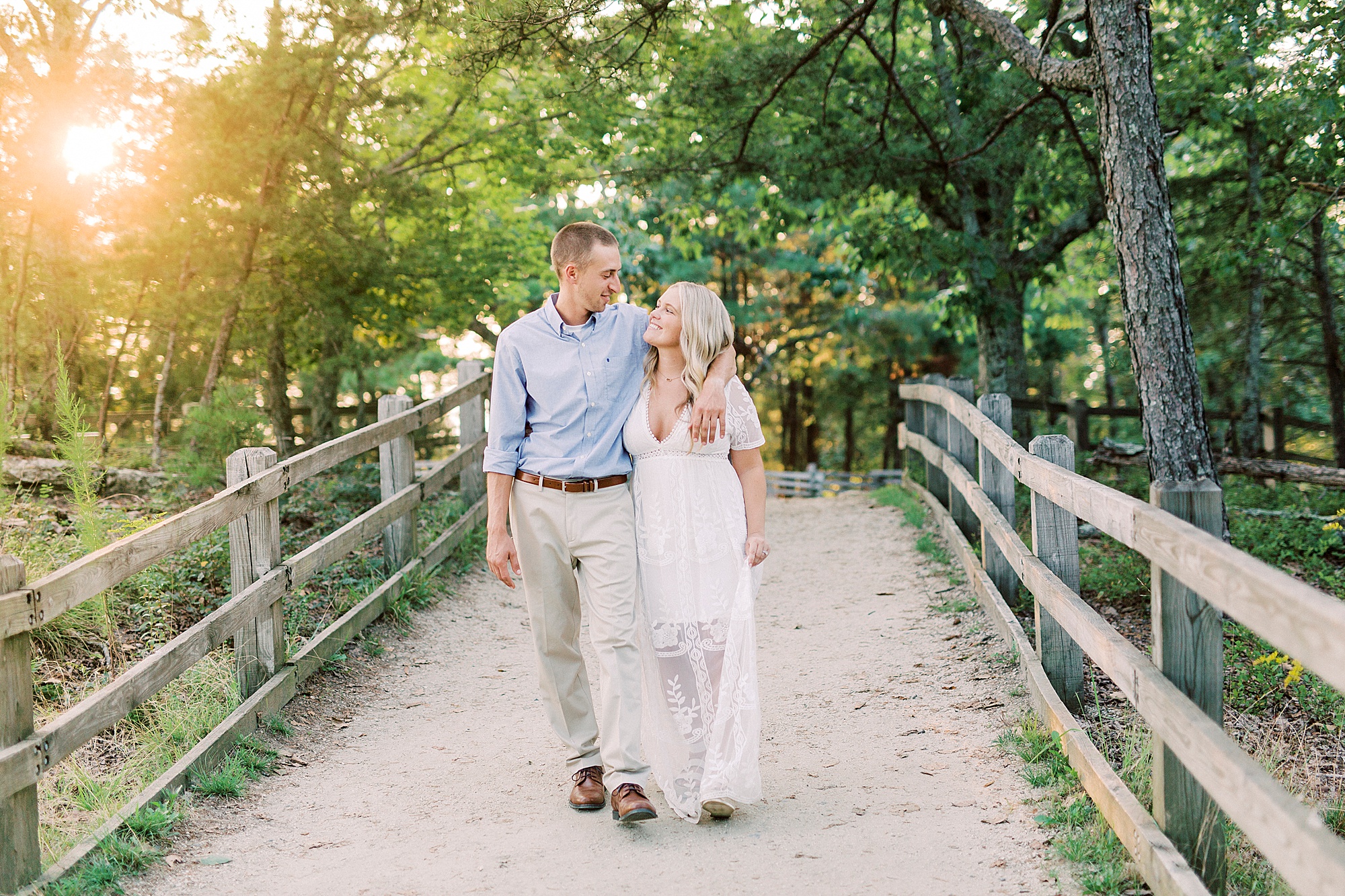 engaged couple walks on wooden bridge during Mount Airy engagement session