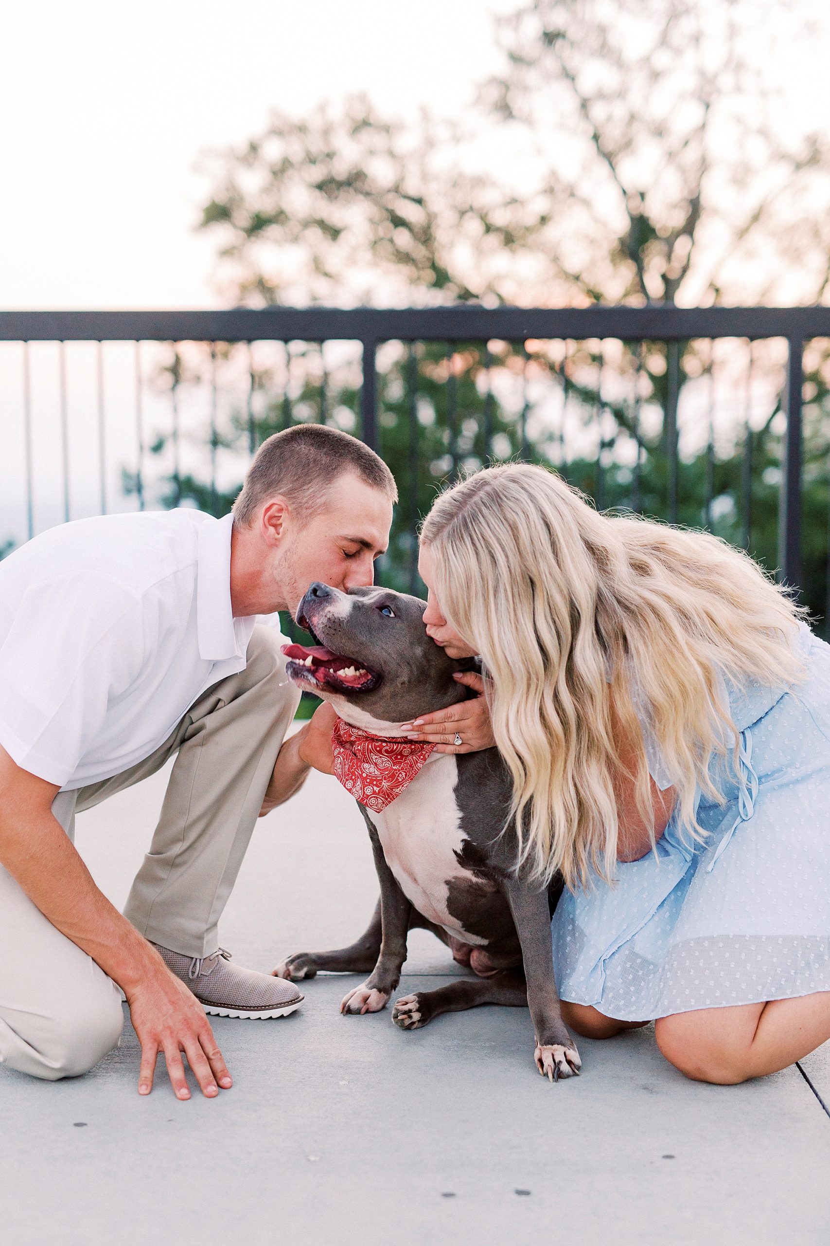 engaged couple kisses dog during Mount Airy engagement session