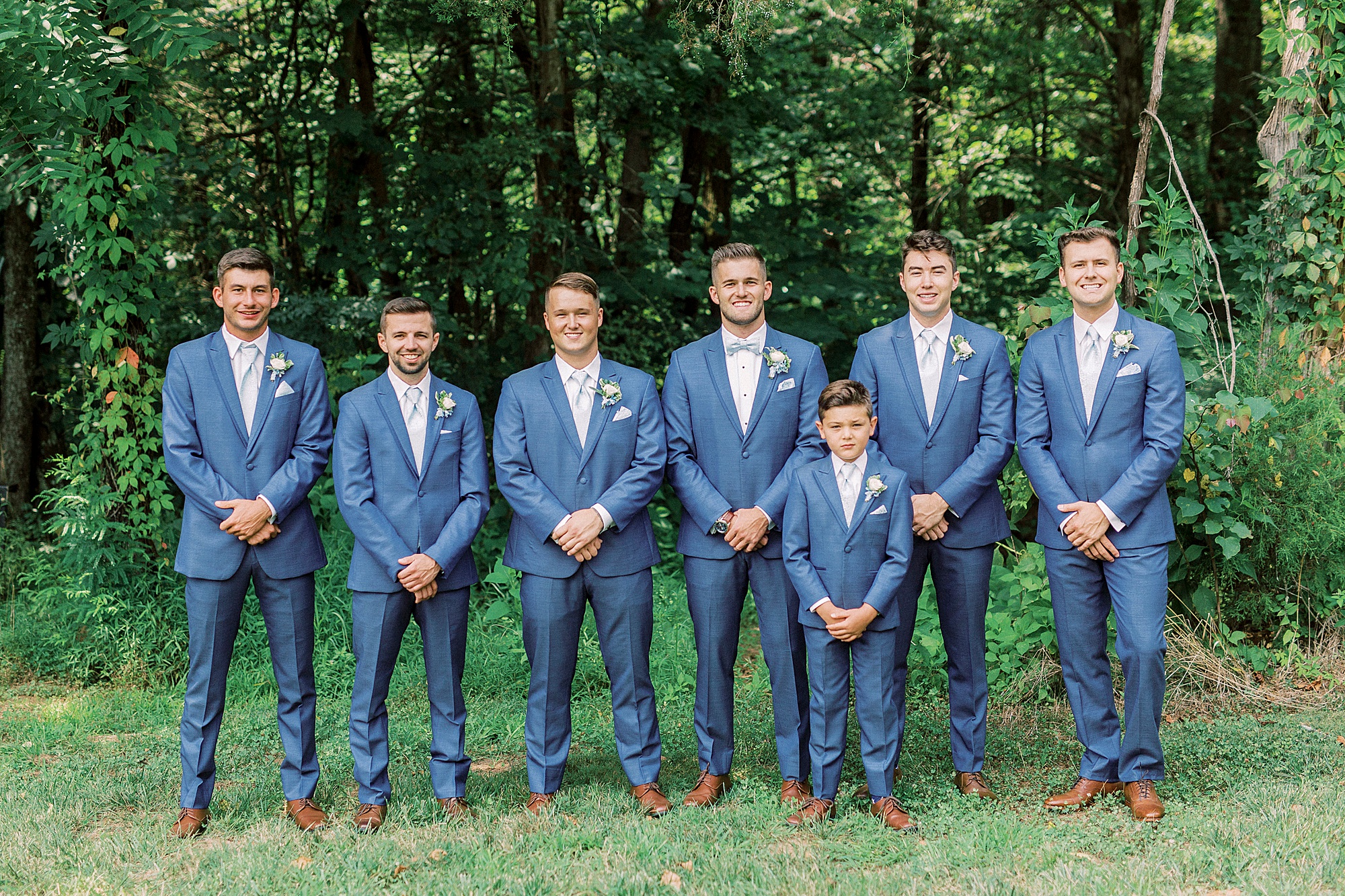 groom and groomsmen pose in navy suits