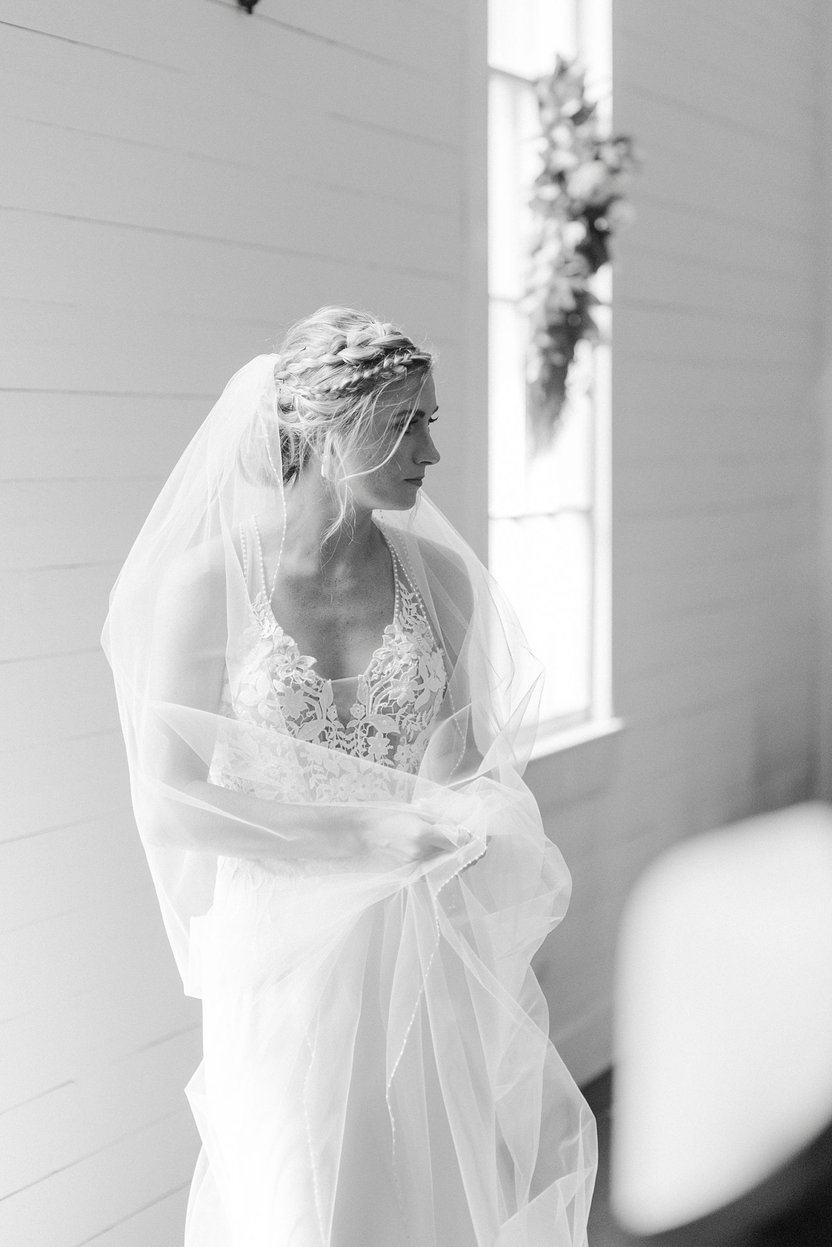 bride poses by church window