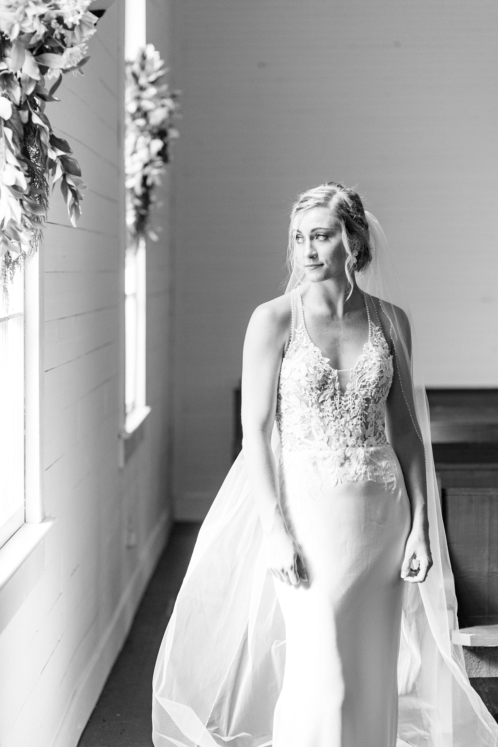 bride looks out window during portraits in church