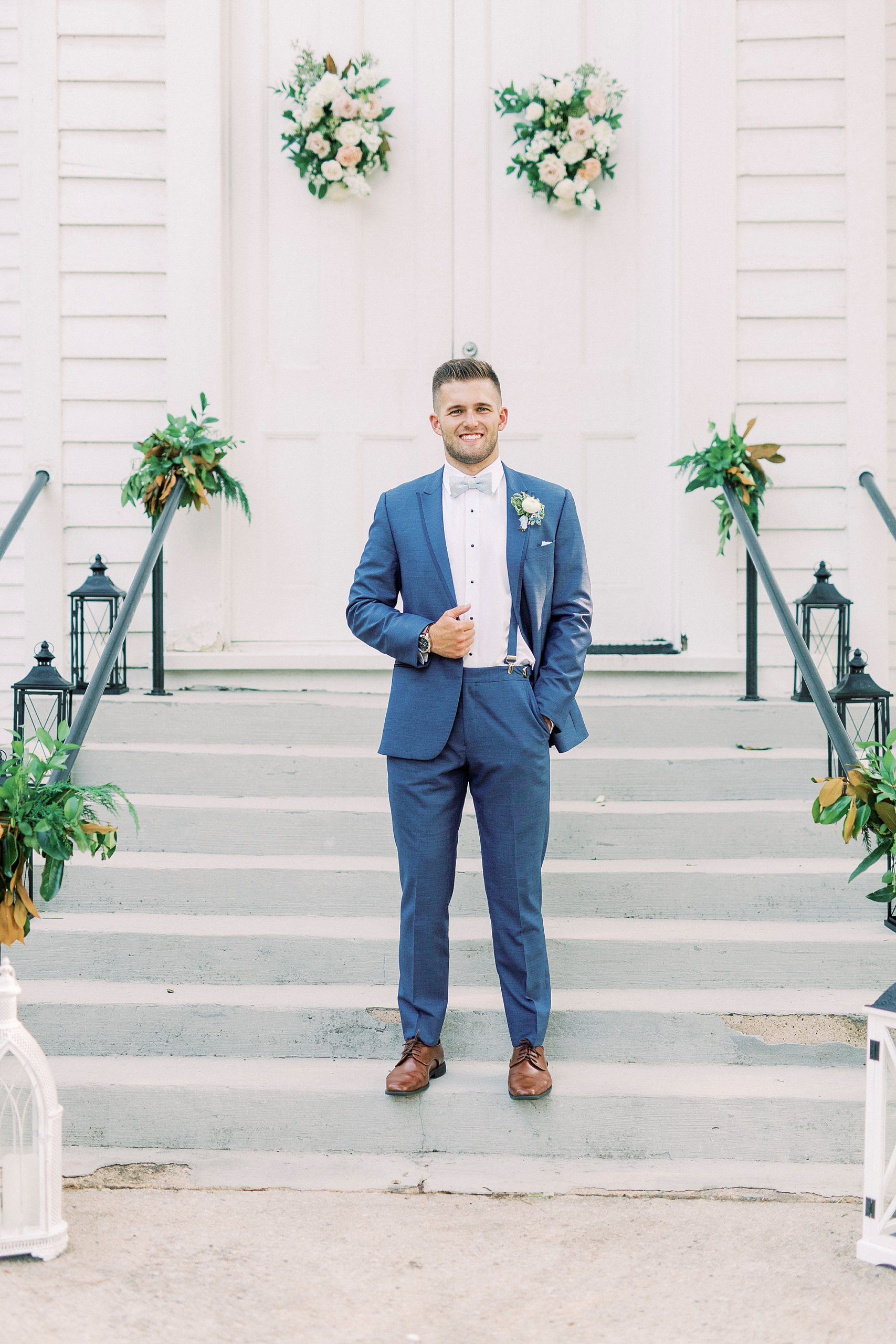 groom in navy suit poses outside Winston-Salem NC church