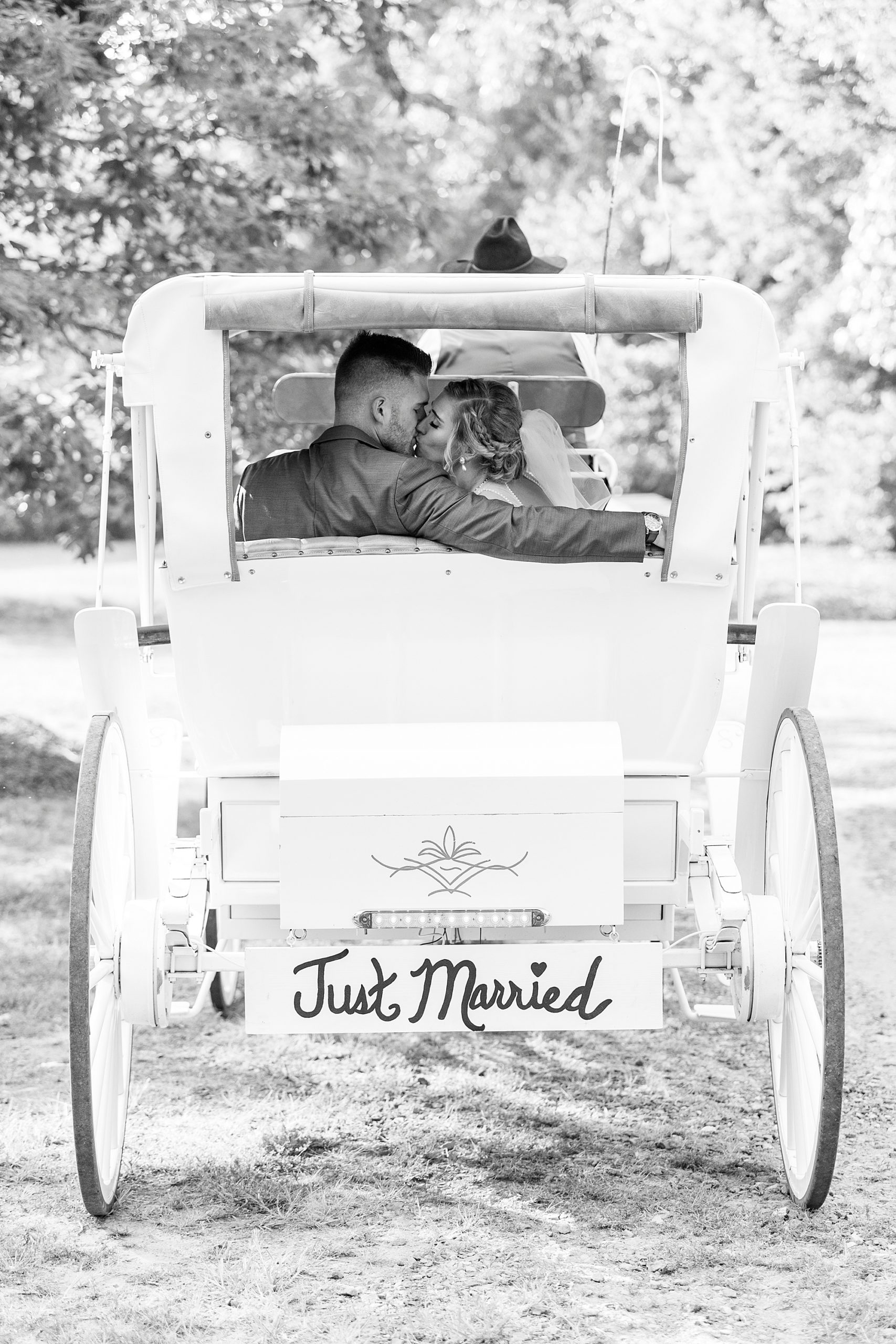 bride and groom drive off in white carriage