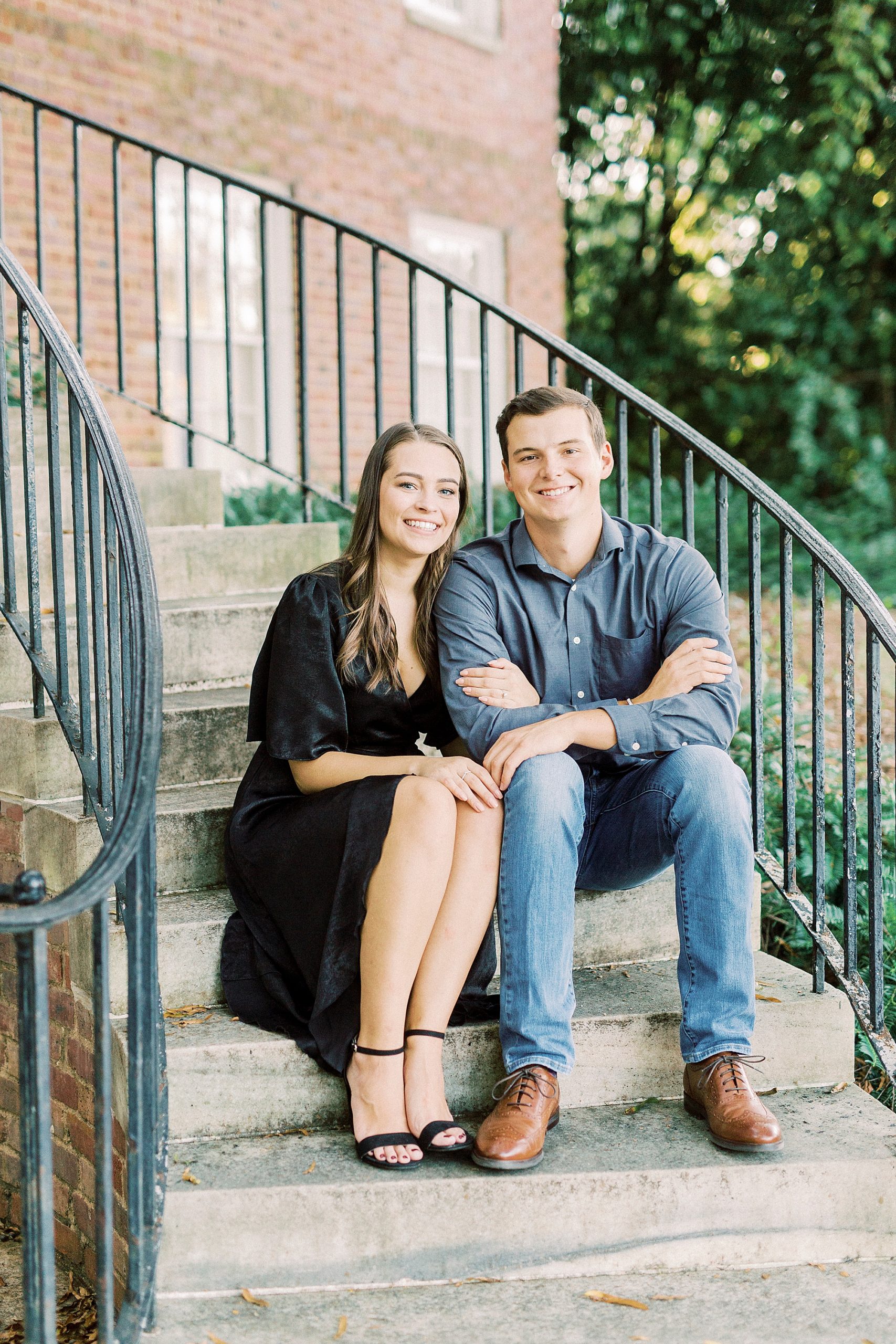 engaged couple sits on steps in Downtown Concord