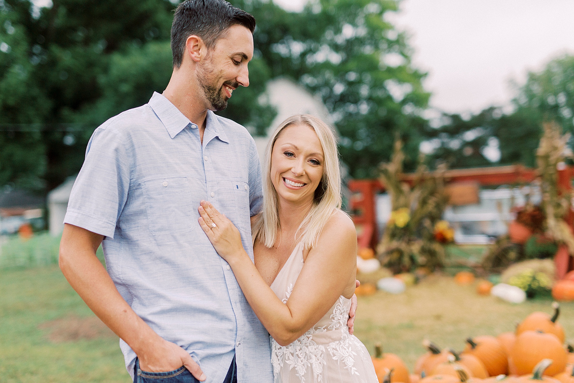 bride hugs groom by pumpkin patch during Hodges Family Farm engagement session