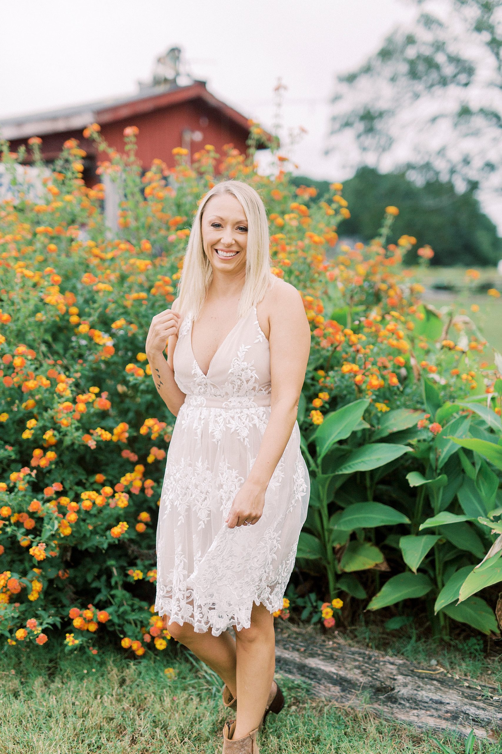 bride poses by orange flowers in Charlotte NC
