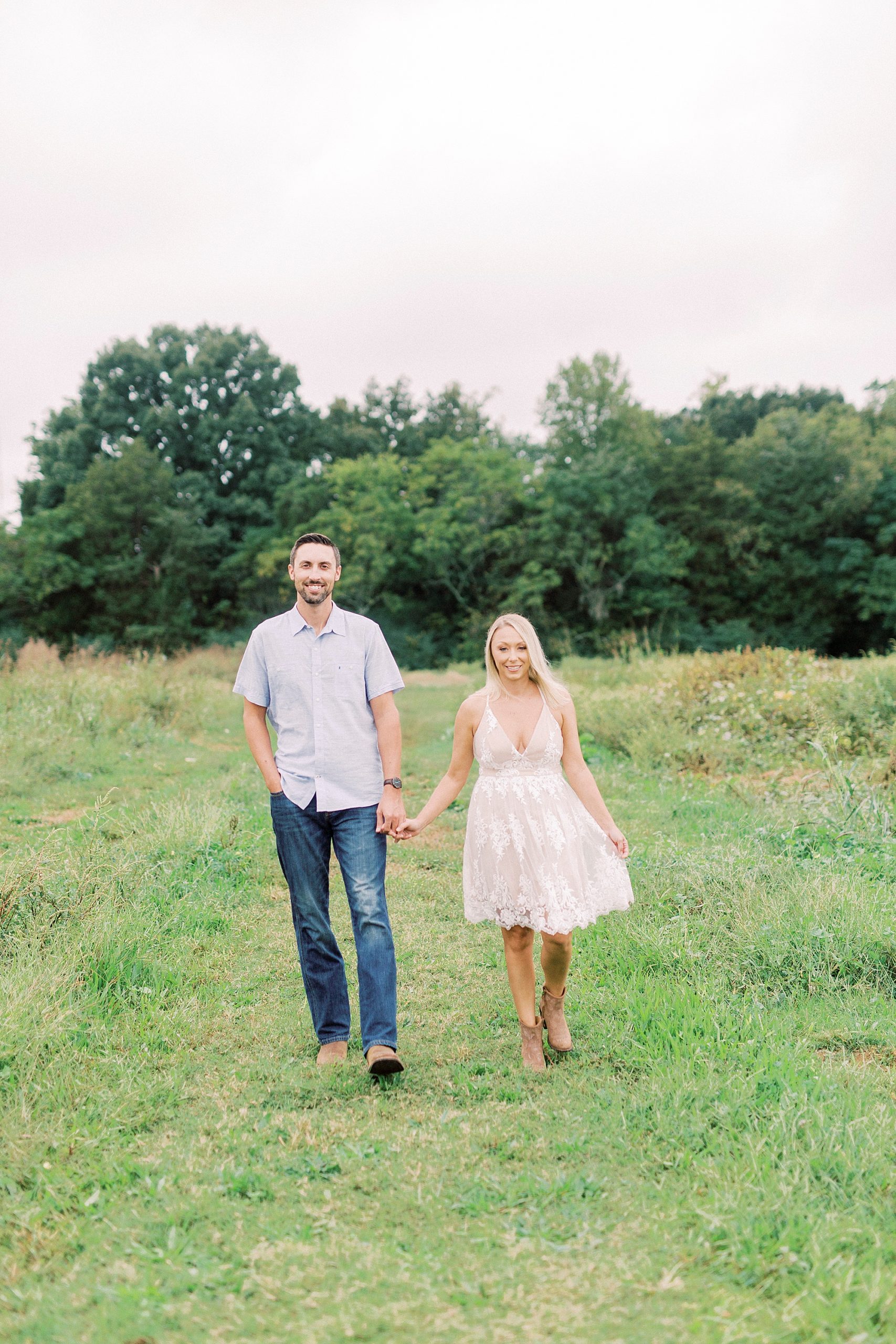 engaged couple walks through field at Hodges Family Farm