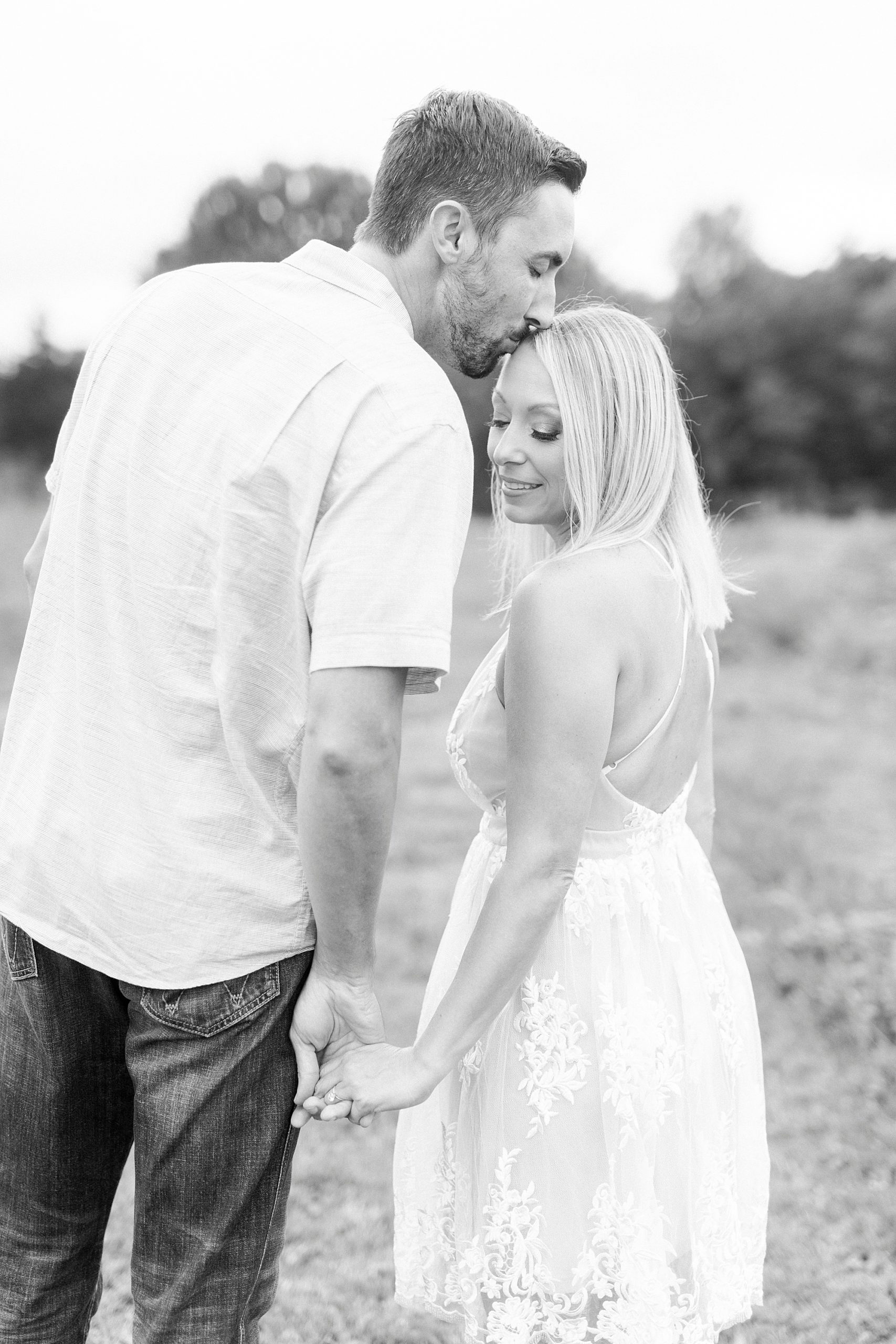 groom kisses bride's forehead during engagement session at Hodges Family Farm