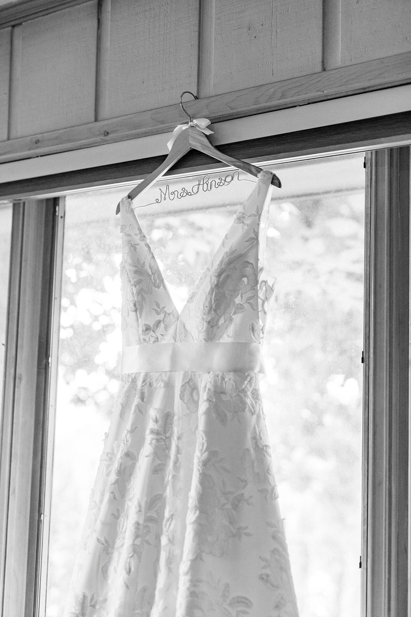 wedding dress hangs in window of the Inn at Crestwood