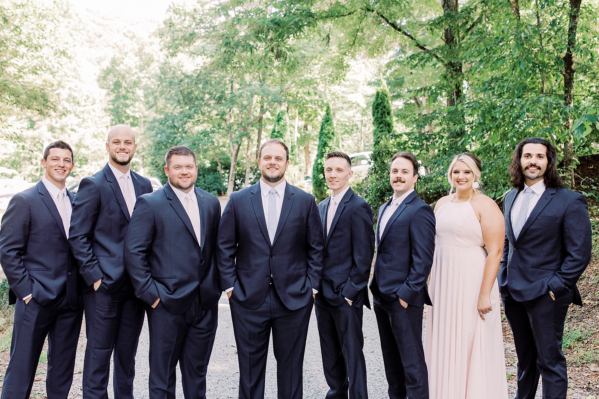groom poses with bridal party before NC wedding