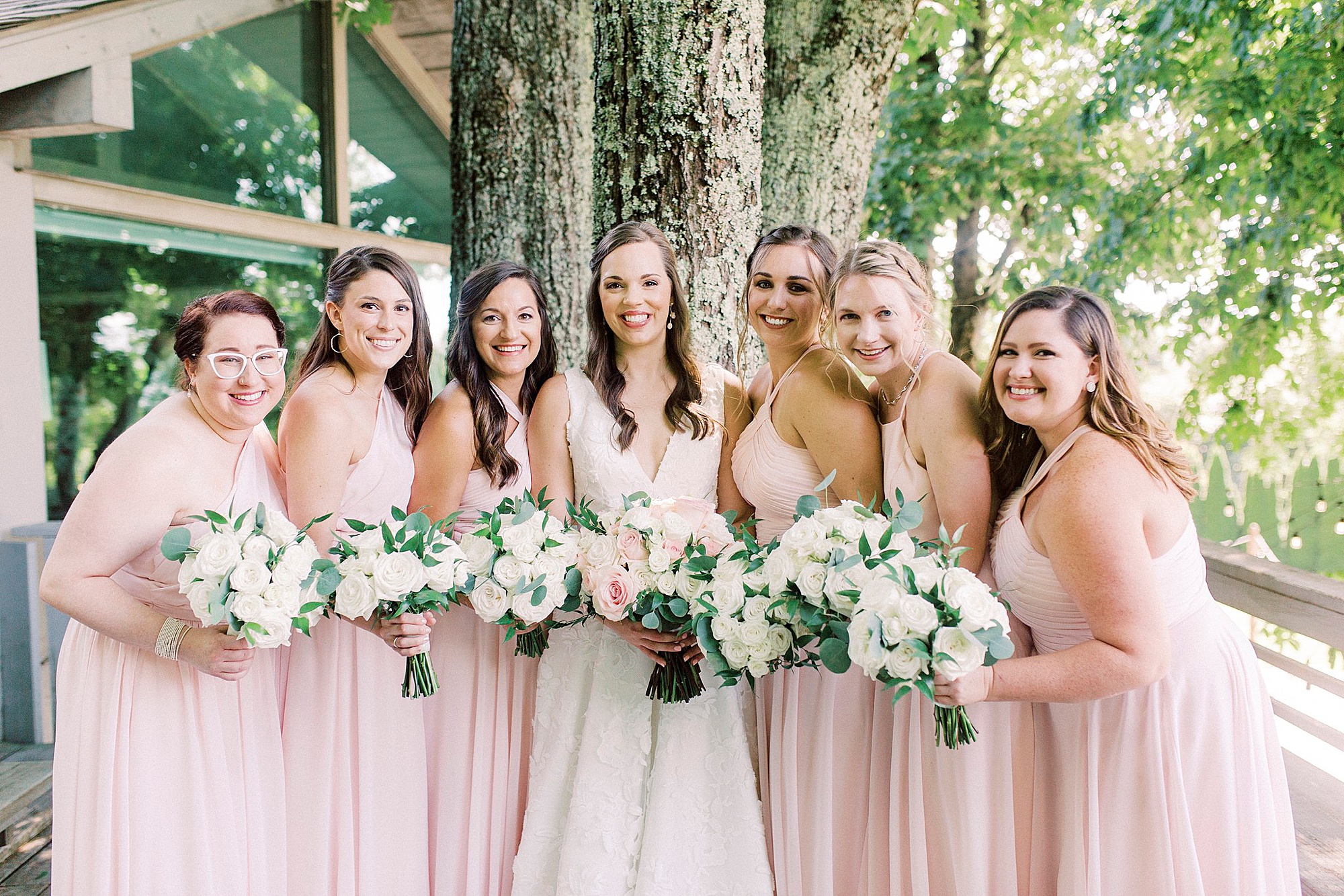 bridesmaids hold bouquets of white and pink flowers for summer wedding