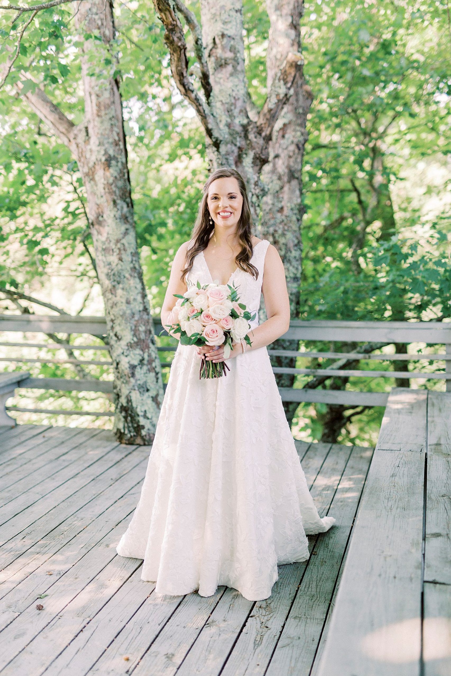bride poses on wooden deck at the Inn at Crestwood