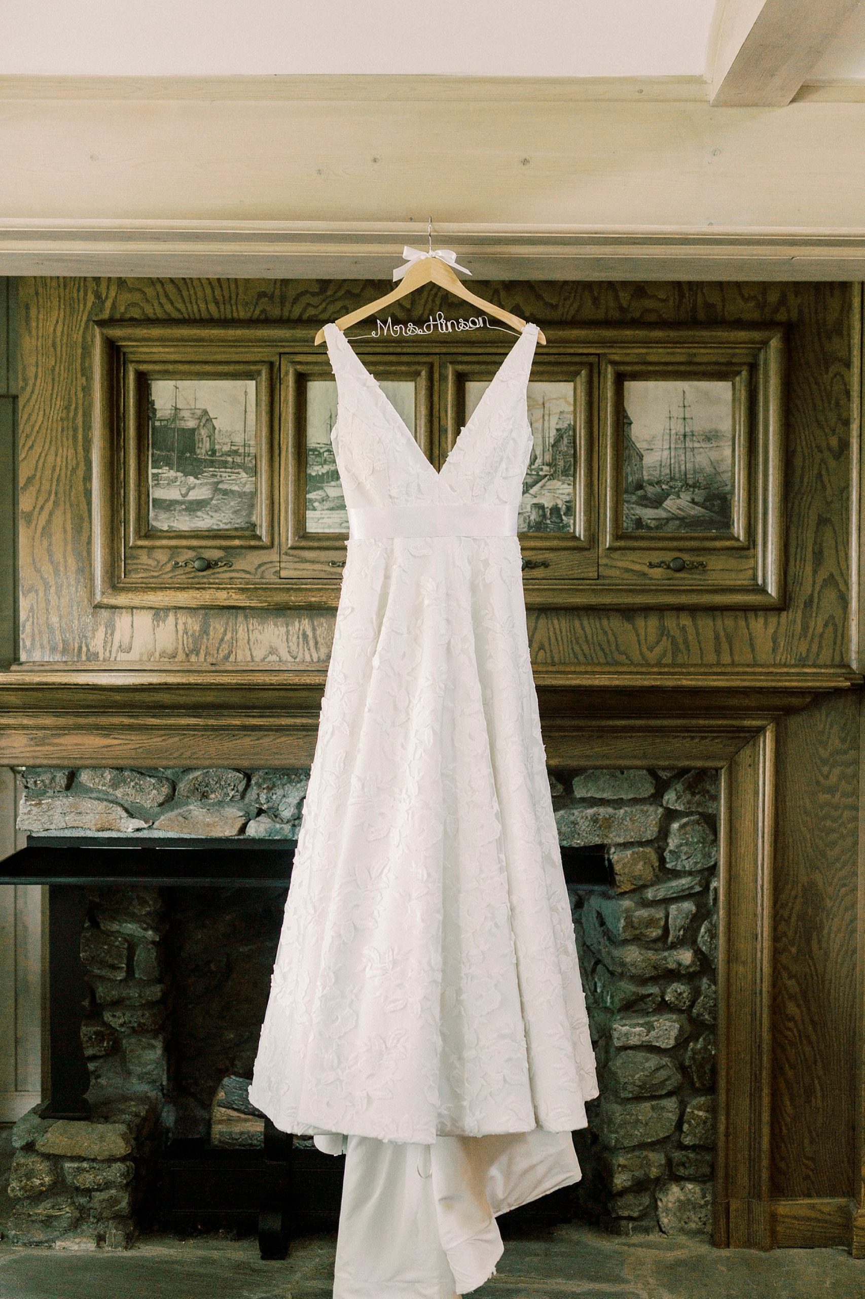 wedding dress hangs over stone fireplace at the Inn at Crestwood
