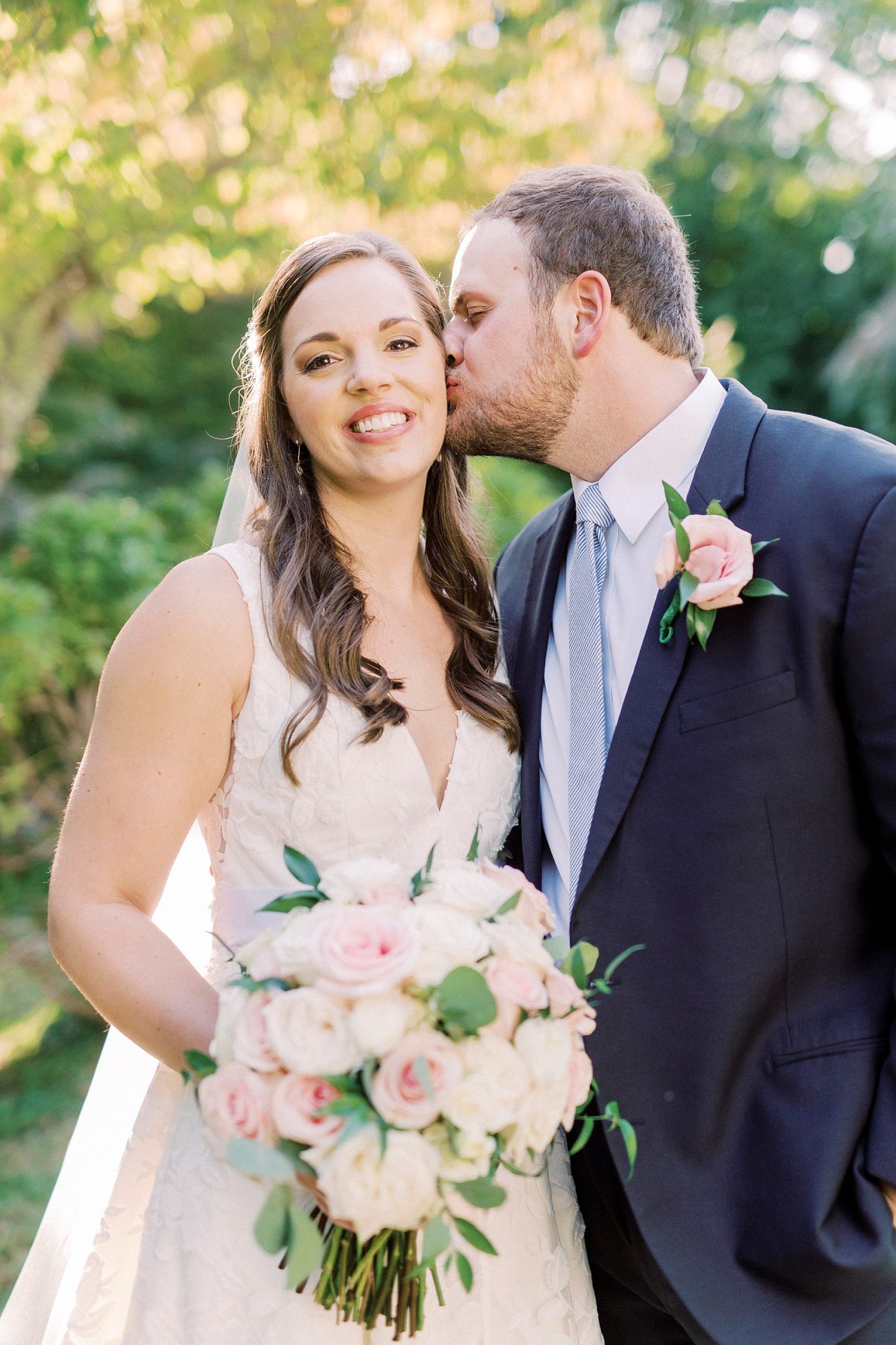groom leans to kiss bride's cheek during NC wedding photos