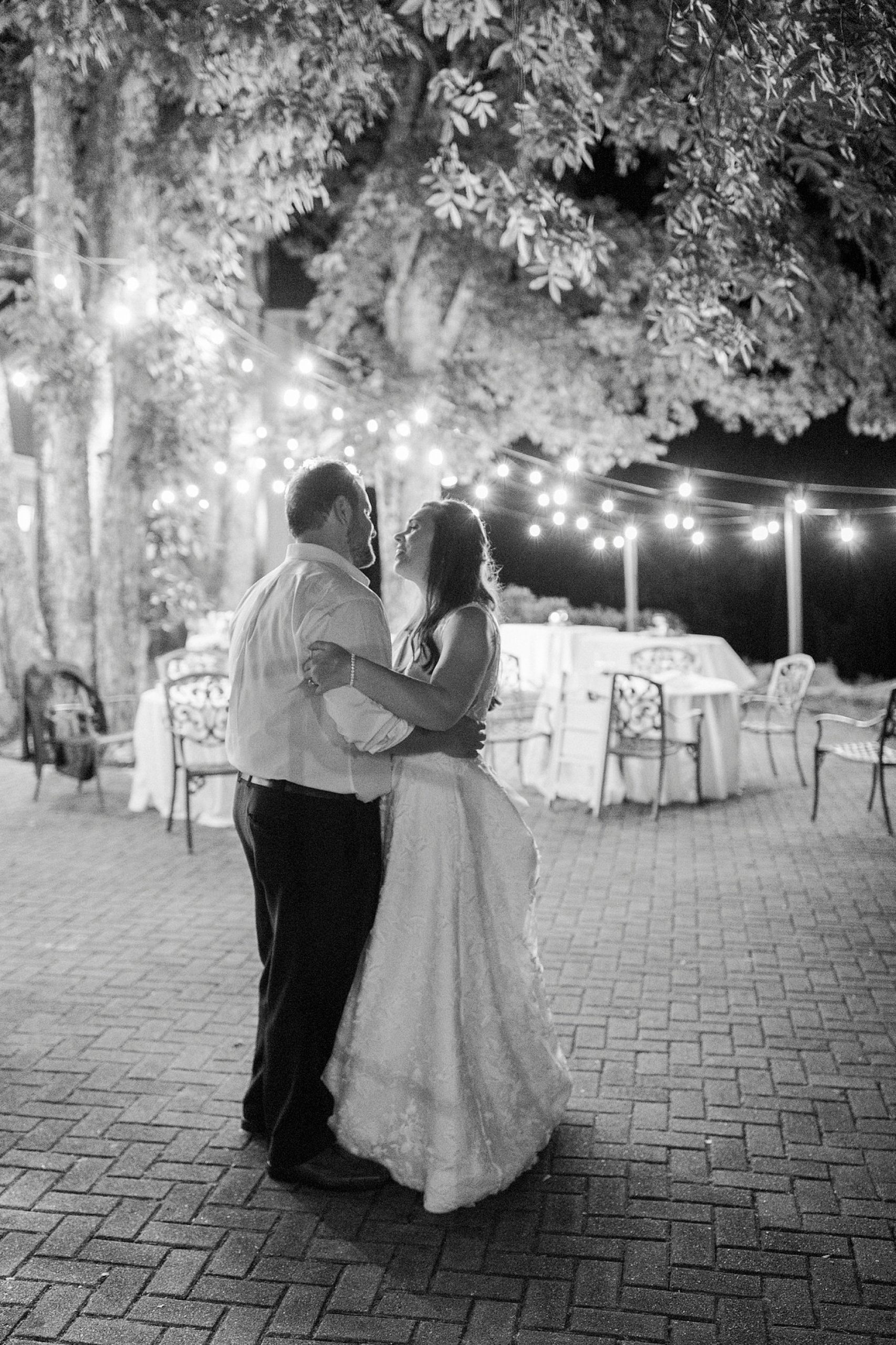 bride and groom dance under bistro lights at Blowing Rock NC wedding reception
