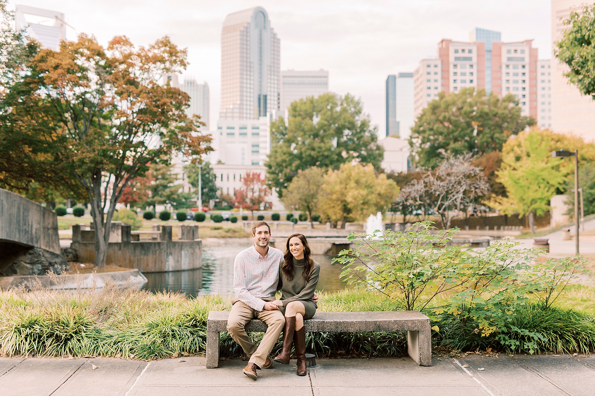 bride and groom sit on bench in Marshall Park during engagement photos