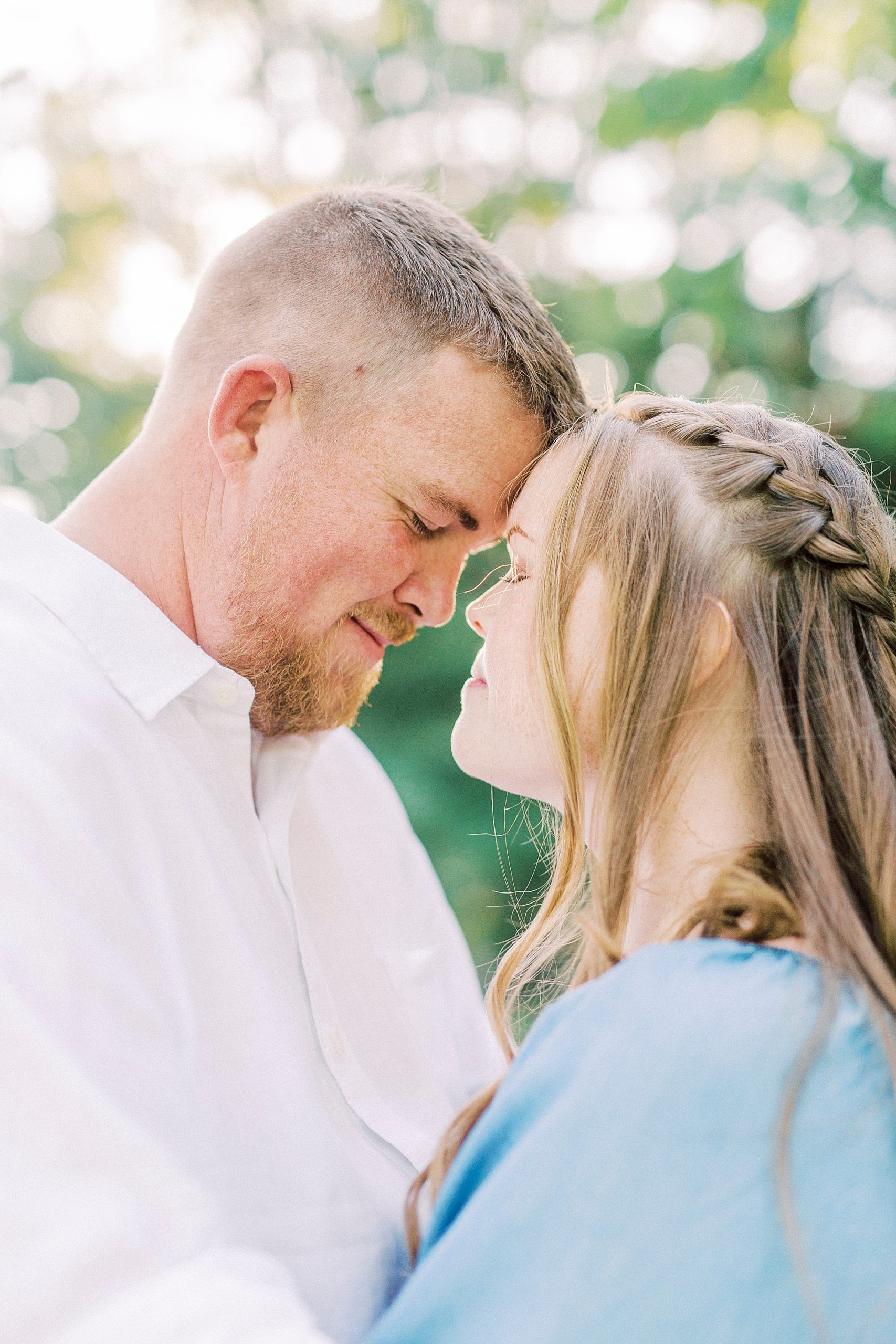 bride and groom stand with noses touching during NC engagement session
