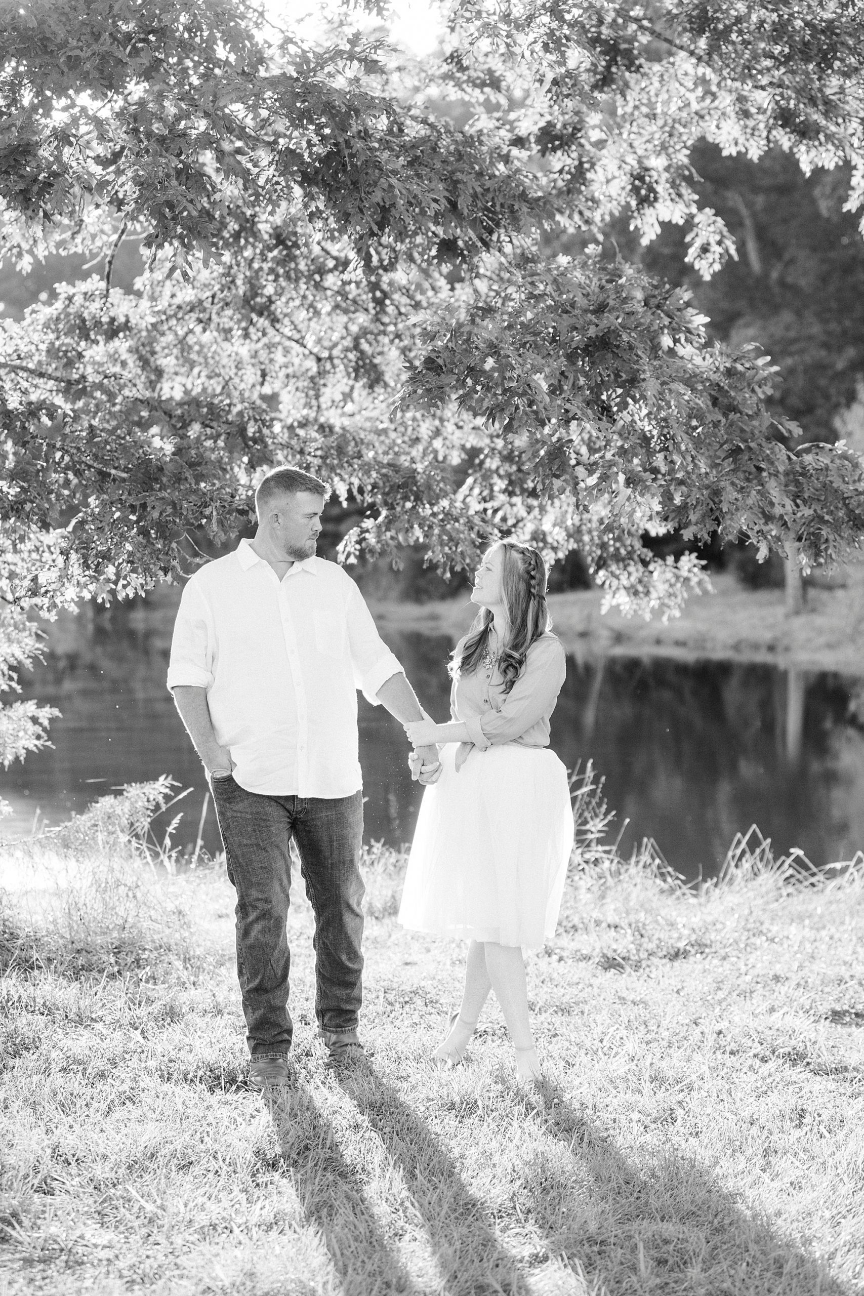 bride holds groom's hand during Concord NC engagement photos