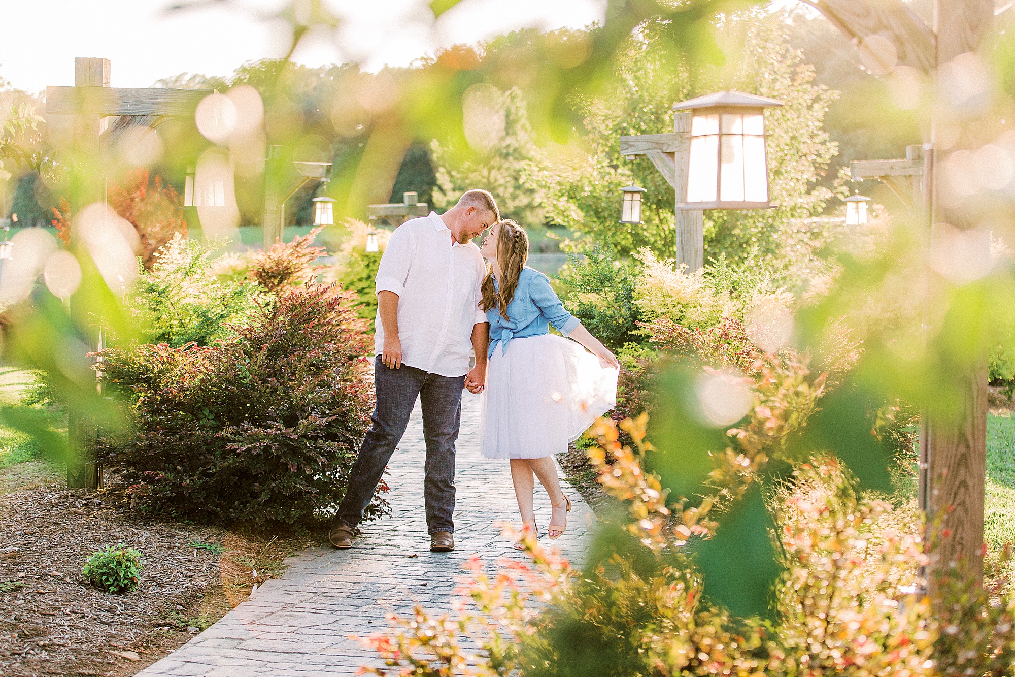 couple kisses on pathway during Sunset Farm engagement session