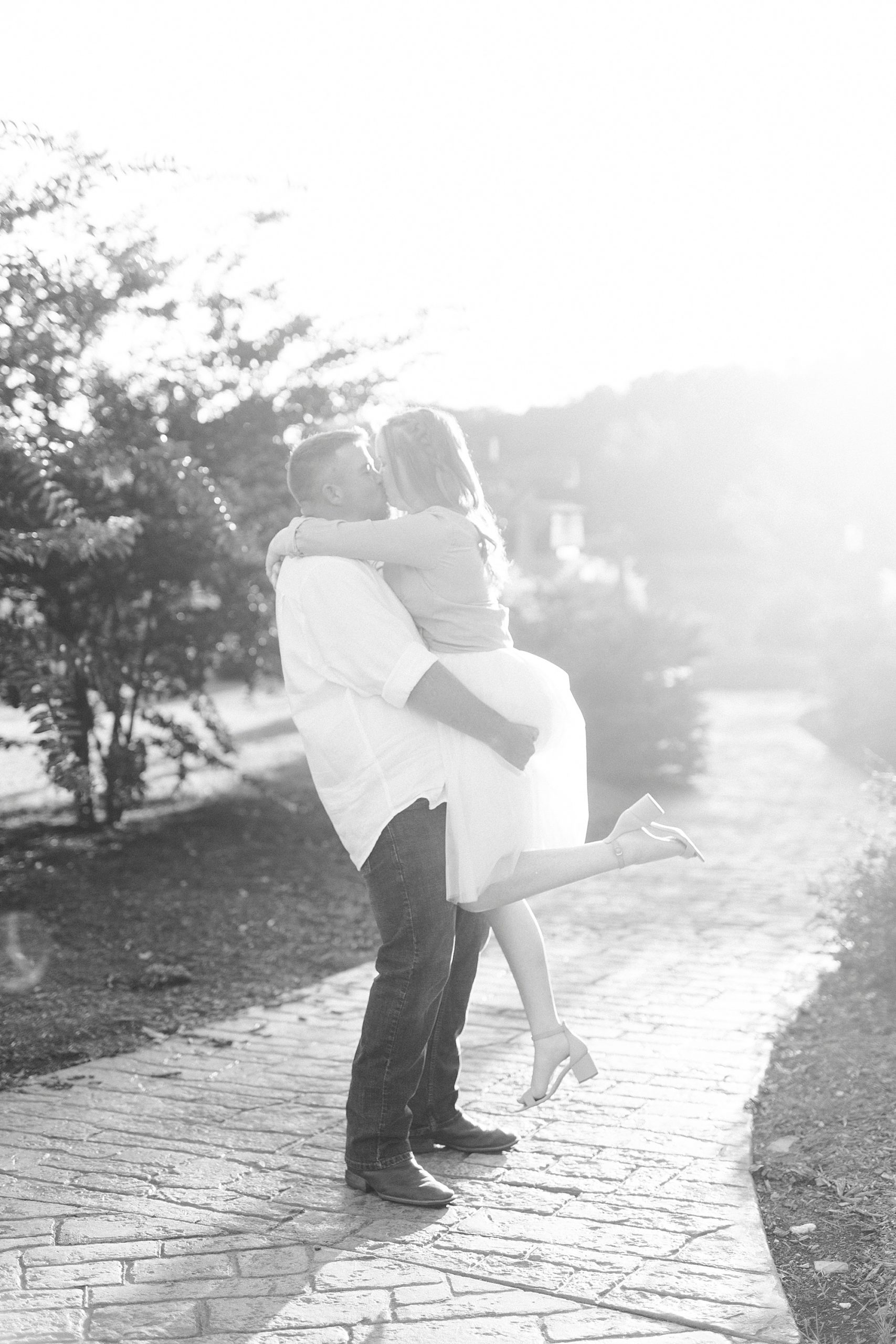 groom lifts bride in tulle skirt up during Sunset Farm engagement session