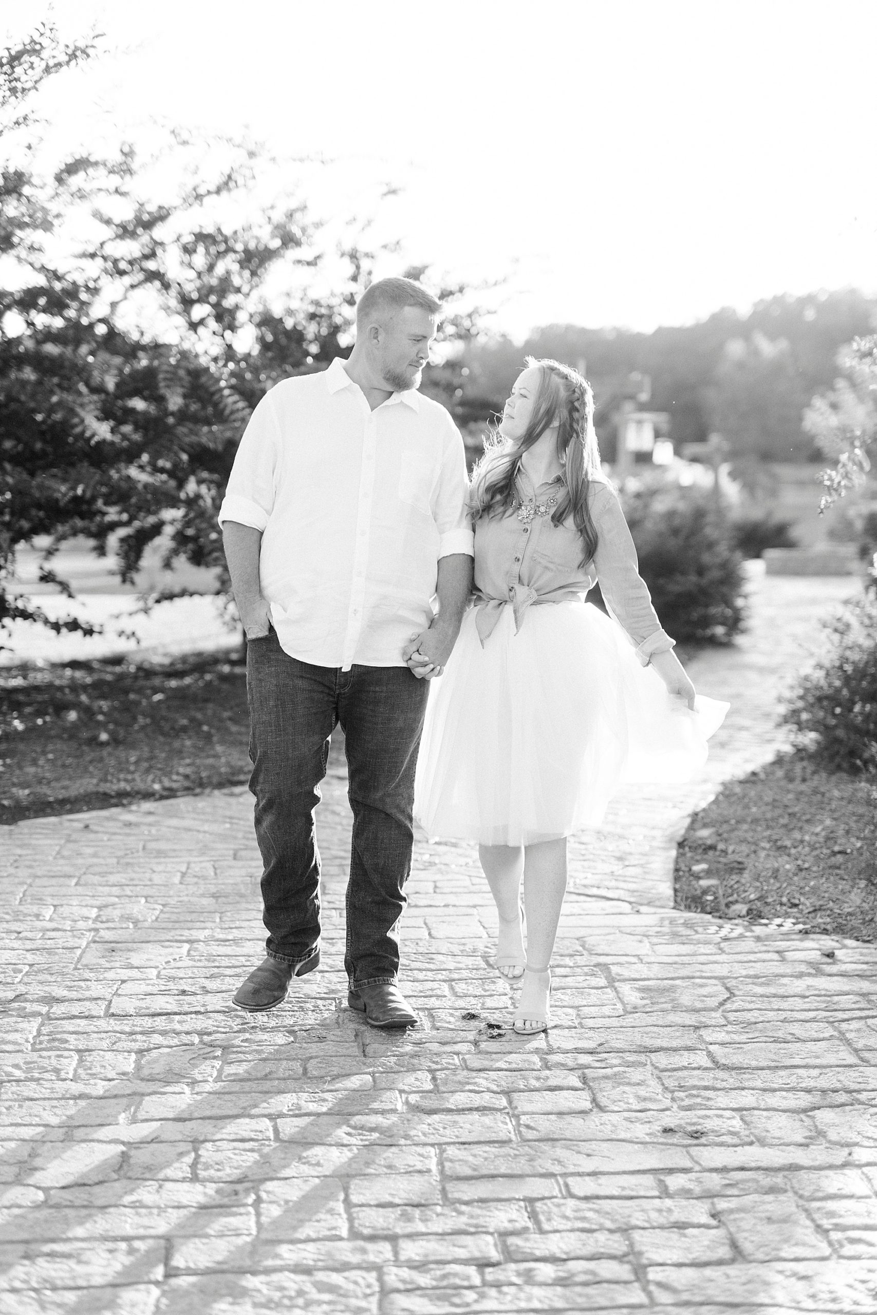 bride and groom hold hands walking during Sunset Farm engagement session