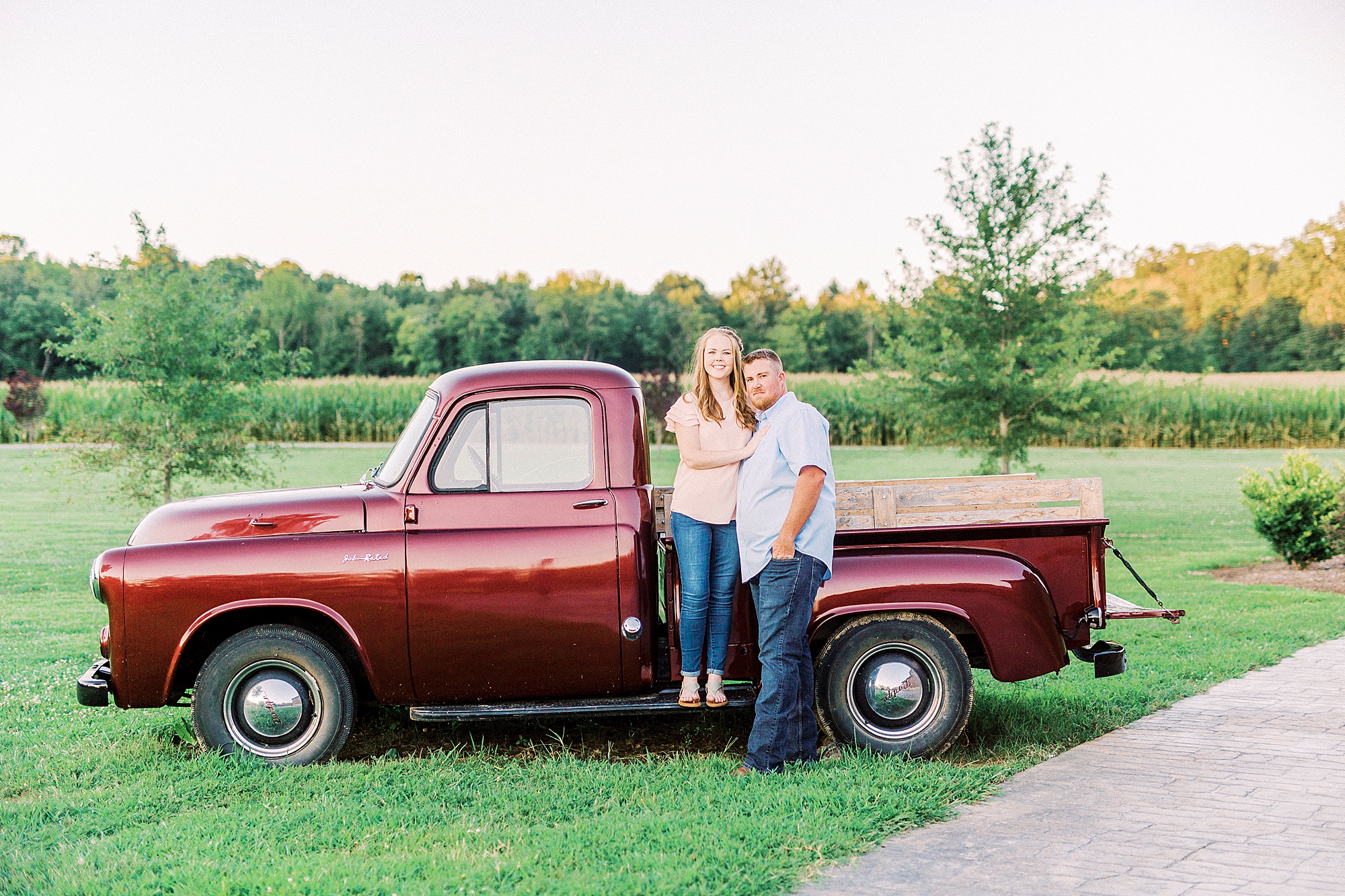 bride and groom sit on vintage red truck