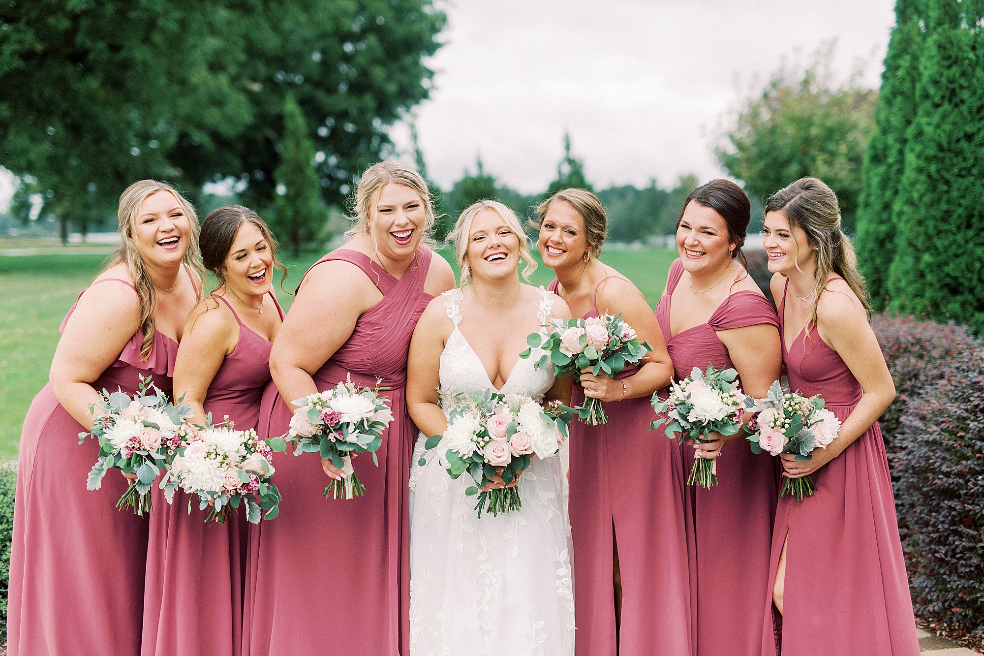 bride laughs with bridesmaids during portraits at Addison Farm