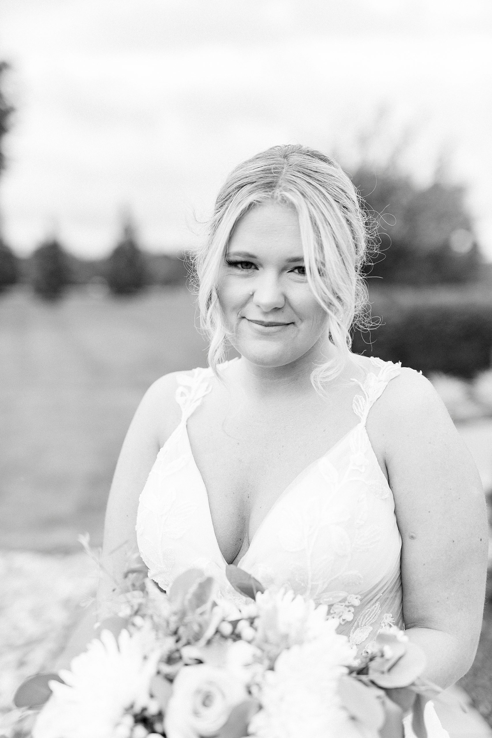 bride holds bouquet on Addison Farm during wedding portraits