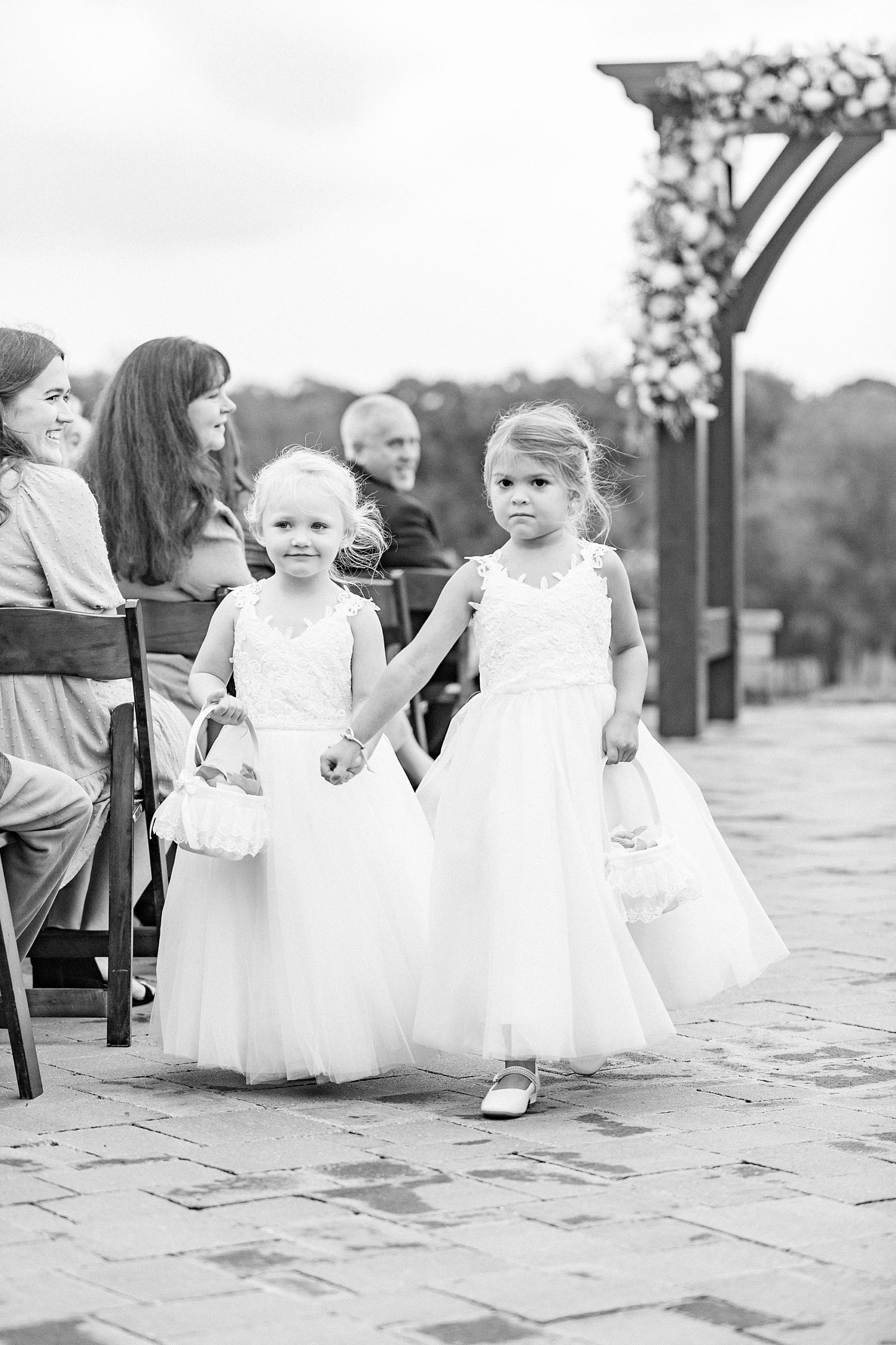 flower girls walk up aisle after outdoor ceremony on farm in Greensboro NC