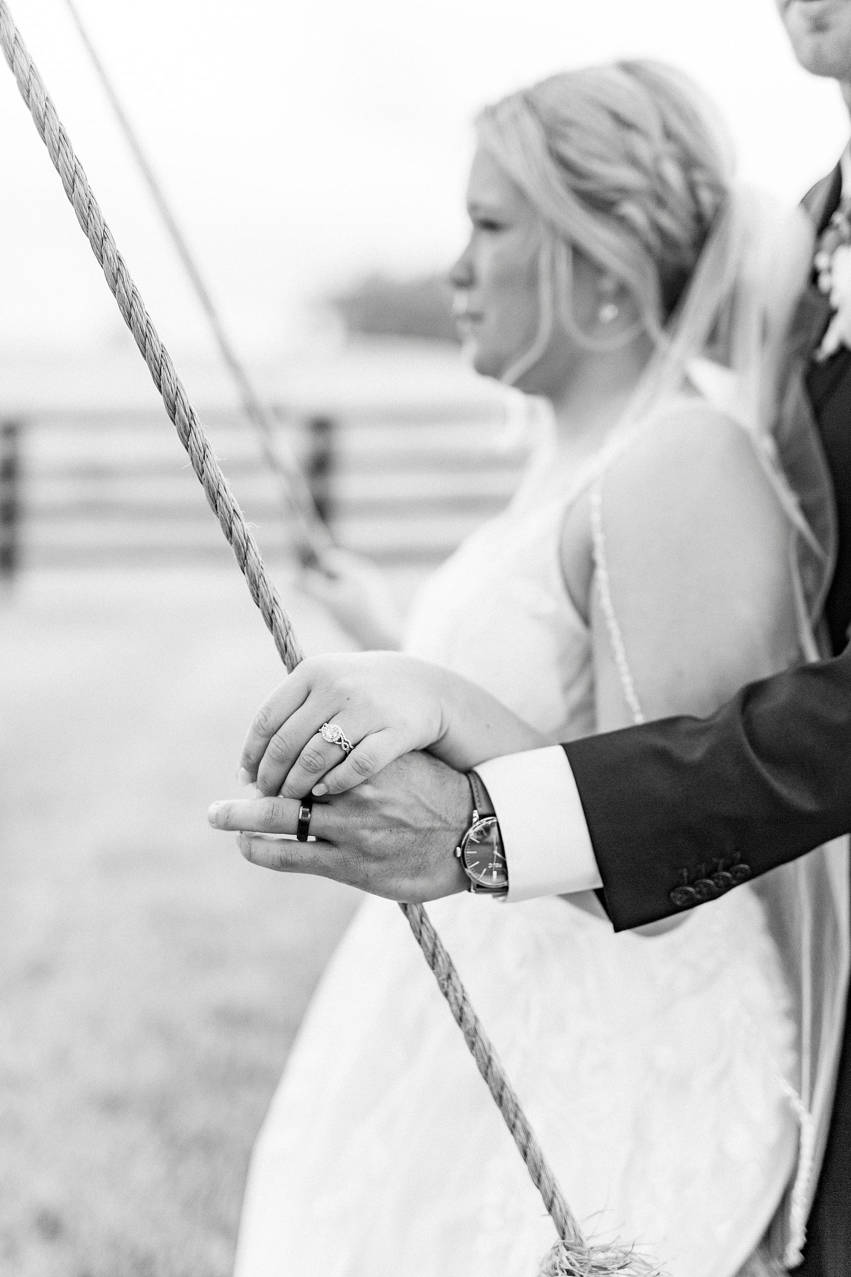 bride and groom sit on wooden swing at Addison Farm