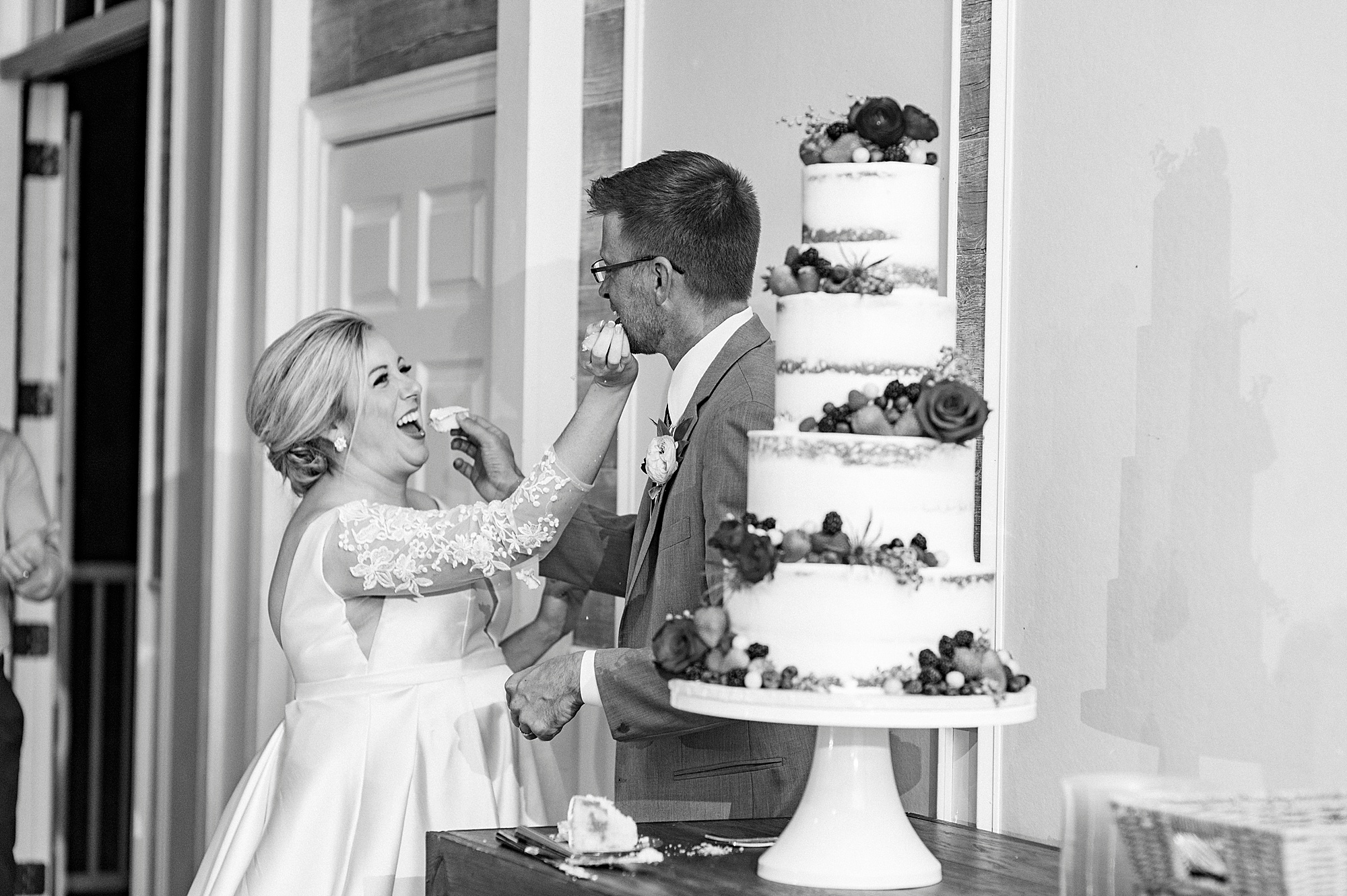 bride feeds groom during NC wedding reception
