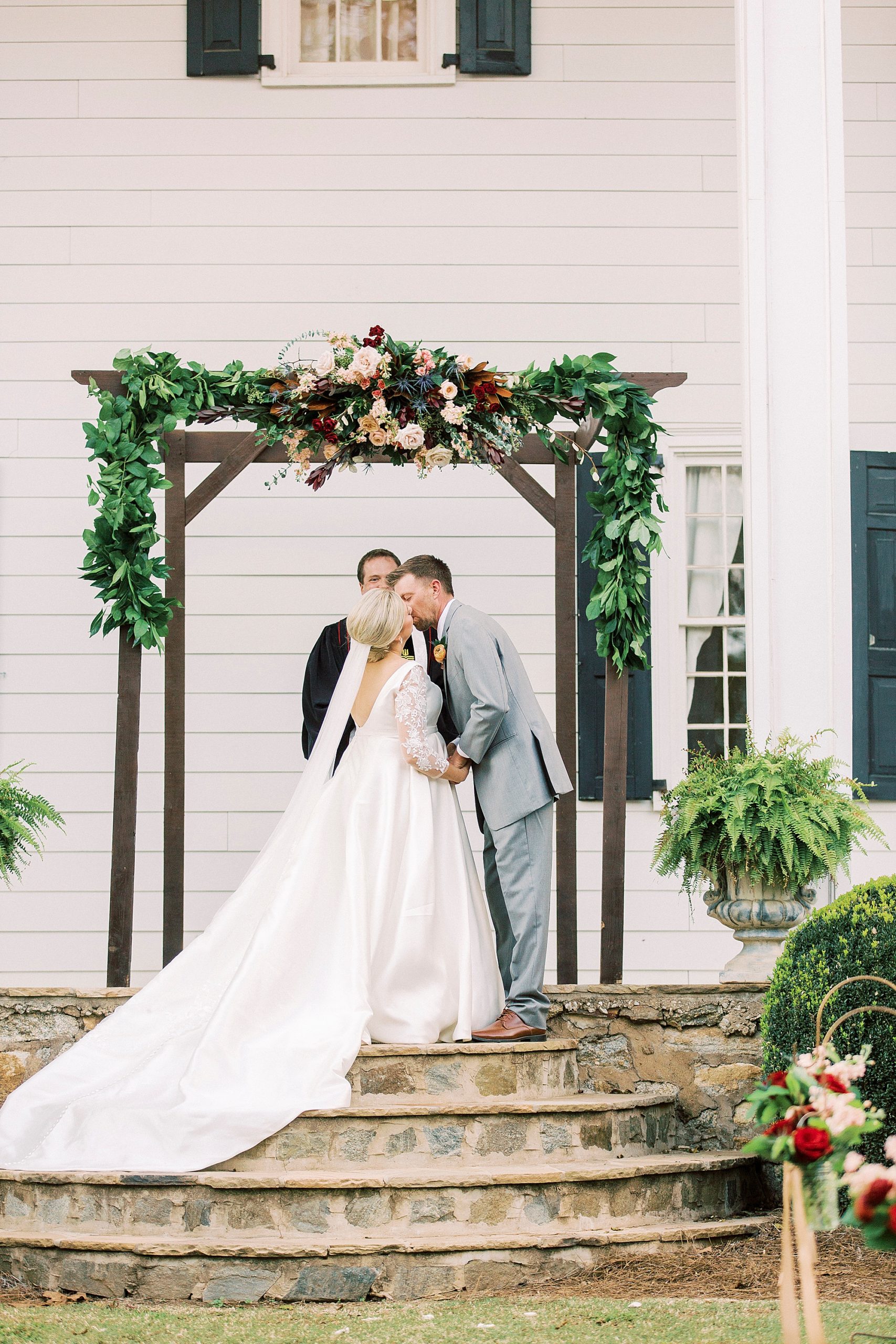 bride and groom have first kiss during NC wedding ceremony at vineyard