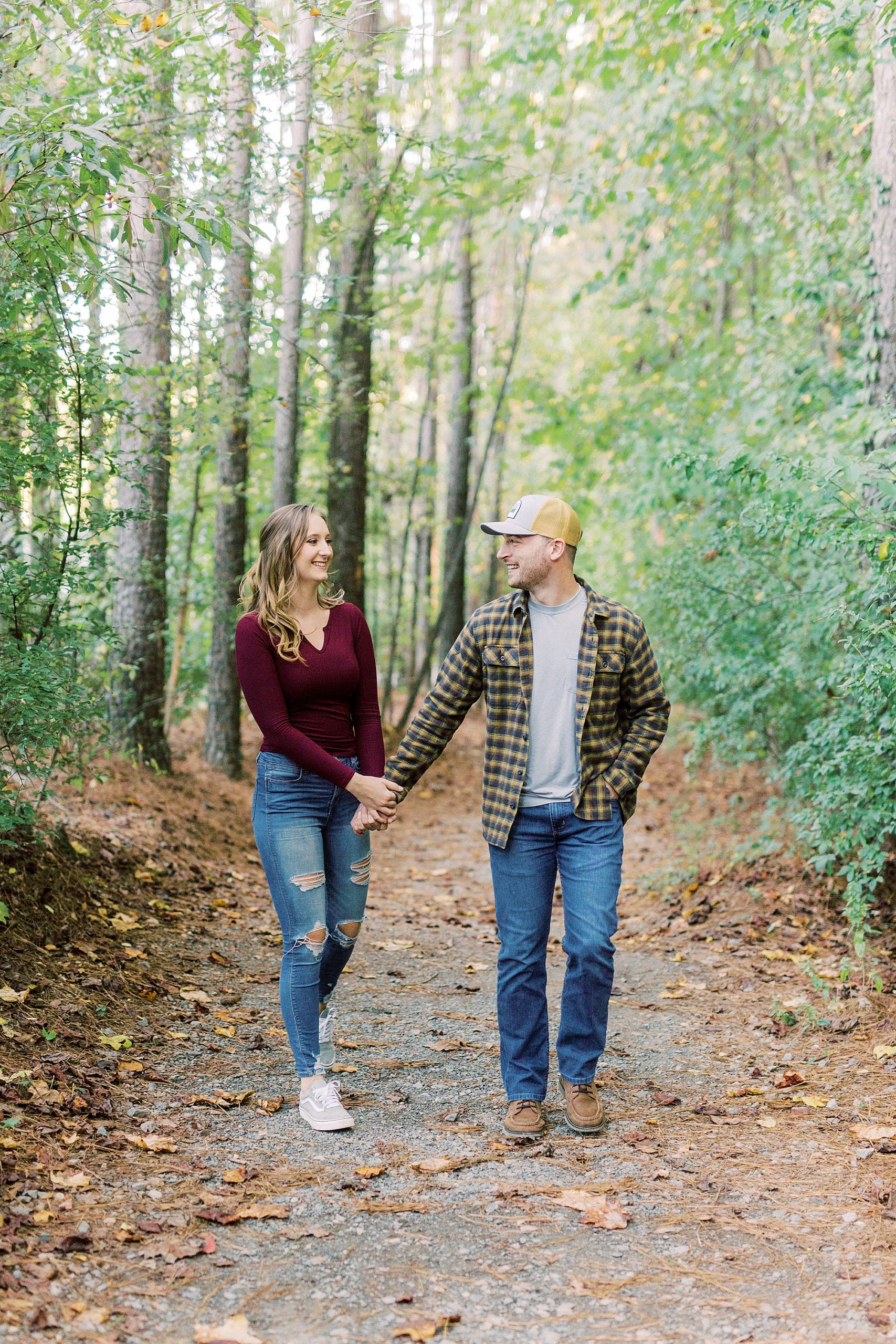 engaged couple walks together through woods at Whitewater Center
