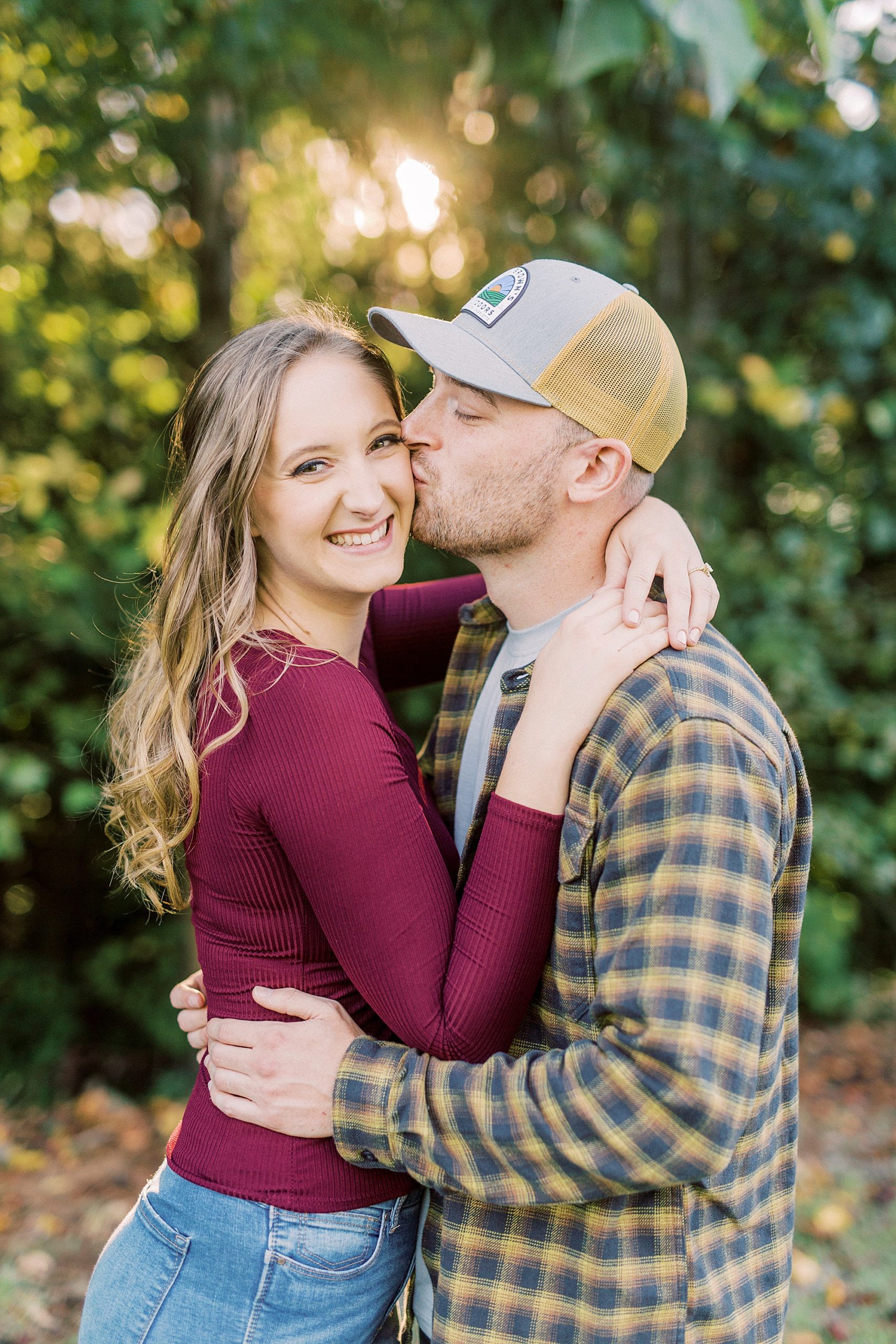 groom kisses bride's cheek during Whitewater Center engagement session