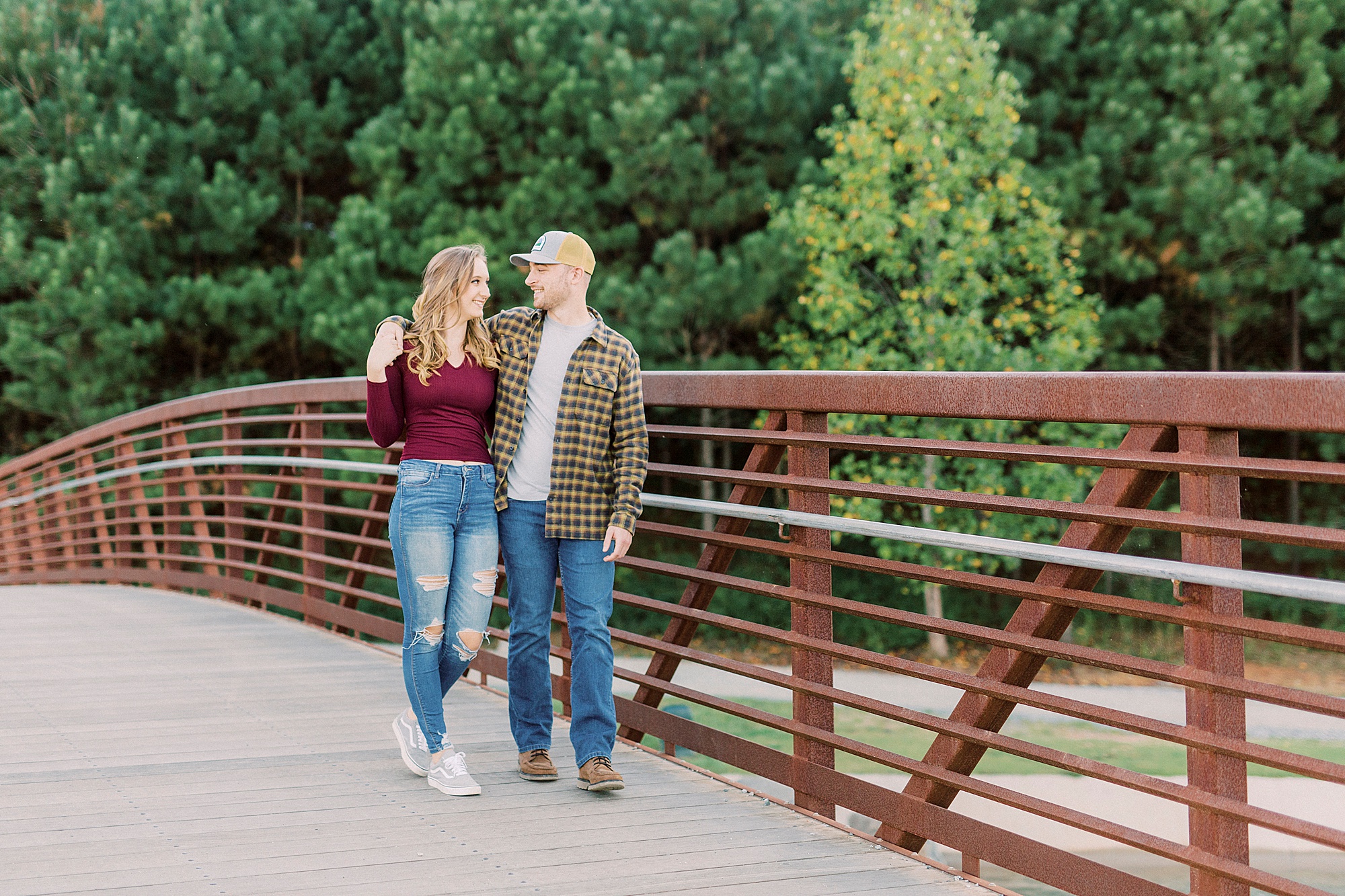 engaged couple walks along bridge at the Whitewater Center