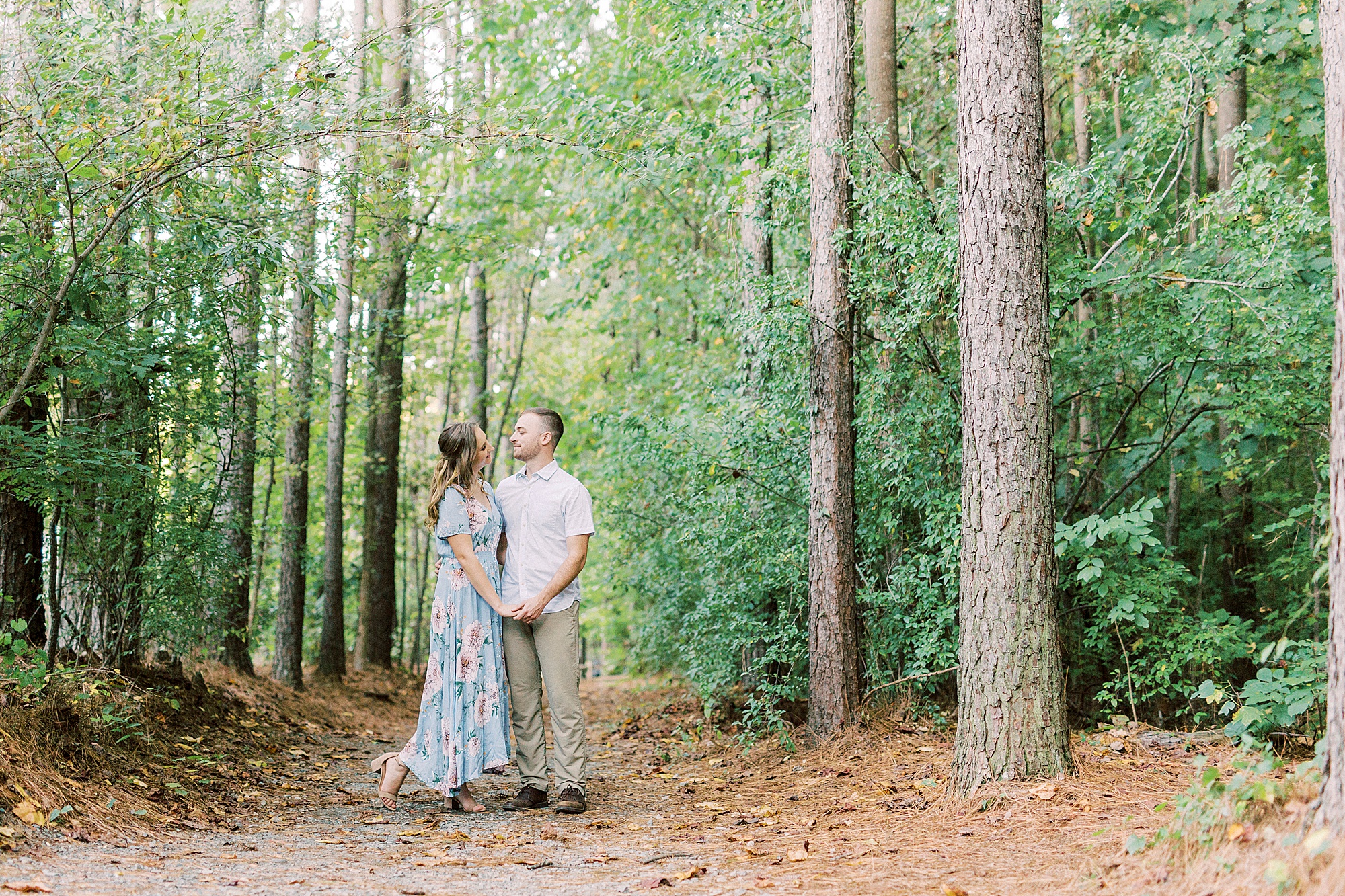 couple stands together in woods during Whitewater Center engagement session