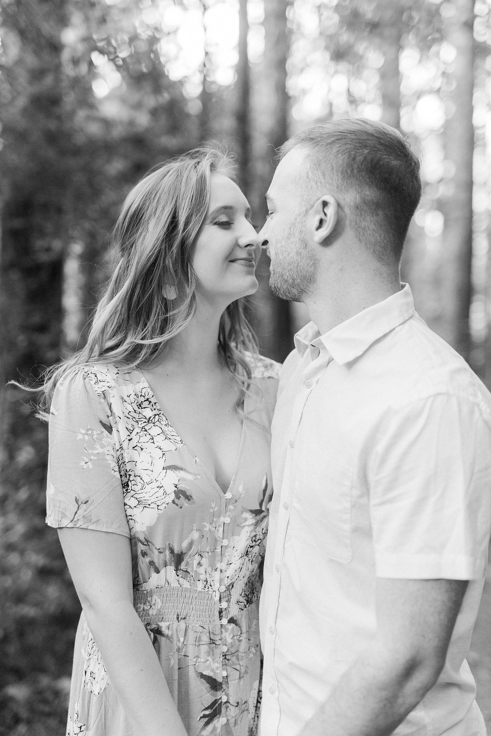 engaged couple stands nuzzling noses during Whitewater Center engagement session