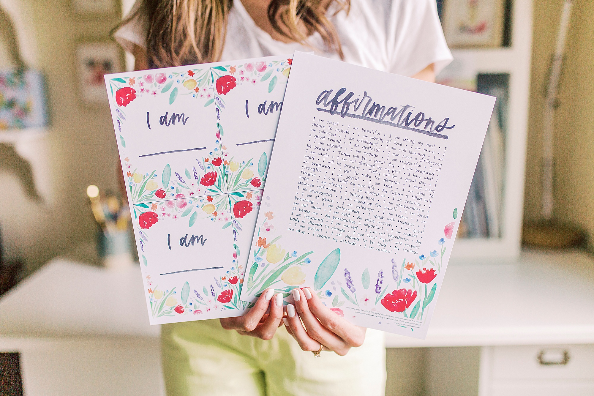 woman holds watercolor affirmations