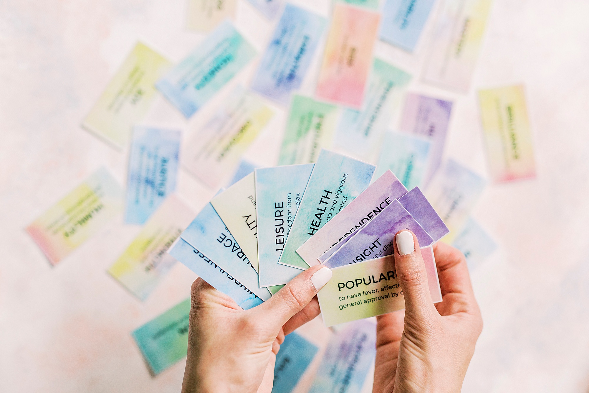 woman holds colored affirmation cards during branding photos at home