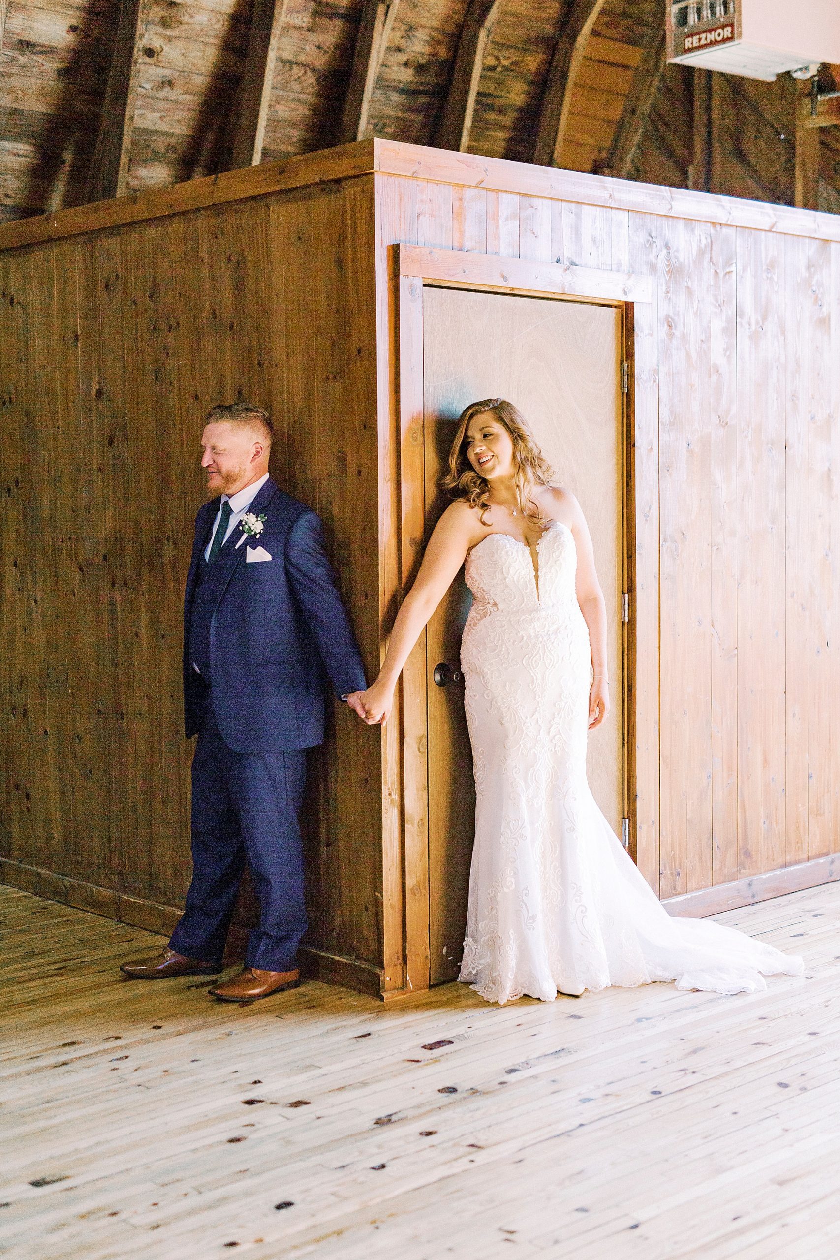 newlyweds have first touch around wall at The Dairy Barn