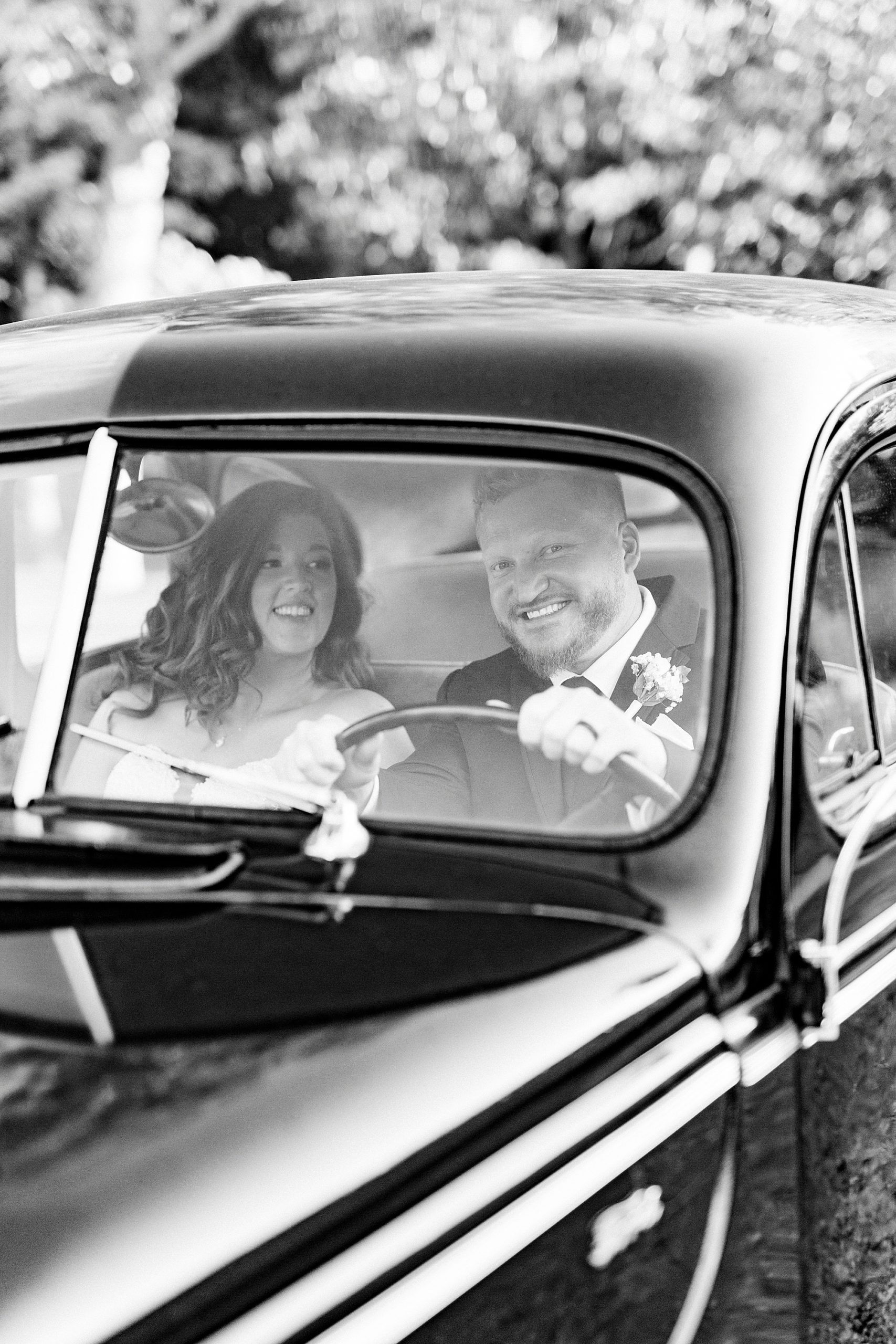bride and groom drive in classic car at The Dairy Barn