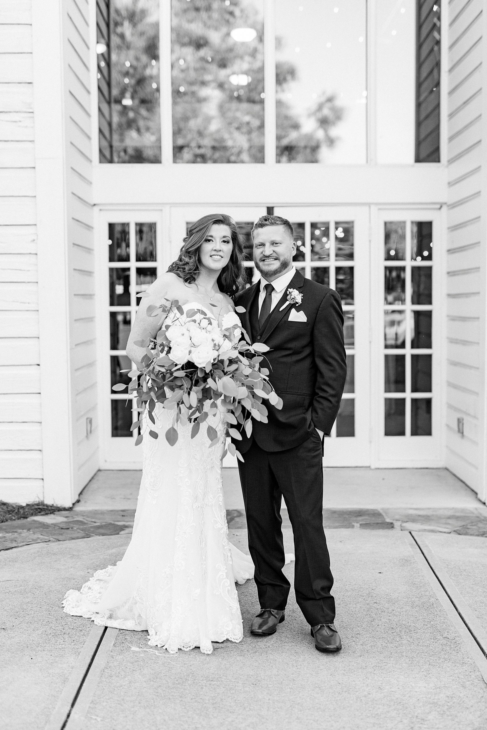 husband and wife pose outside The Dairy Barn on wedding day