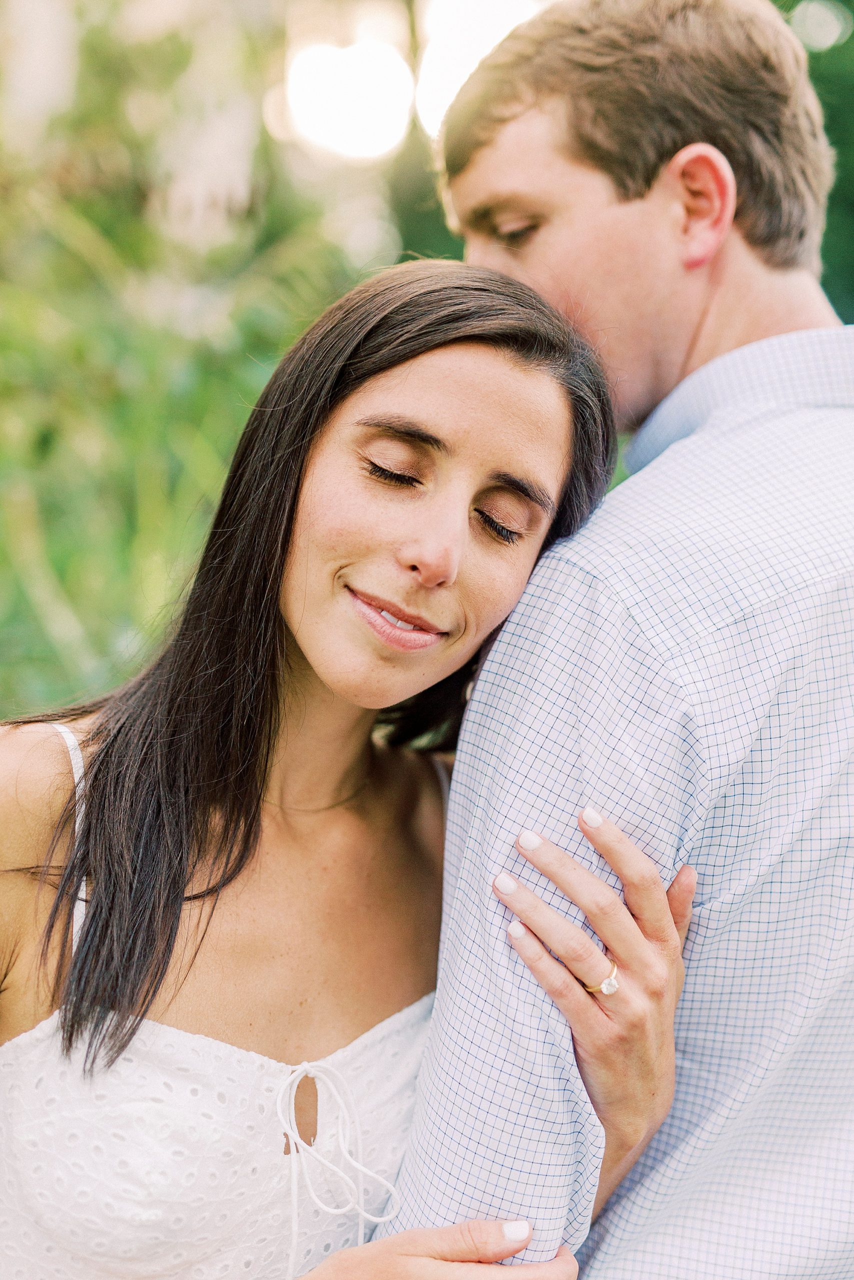 woman leans on man's arm during Midtown Park engagement session